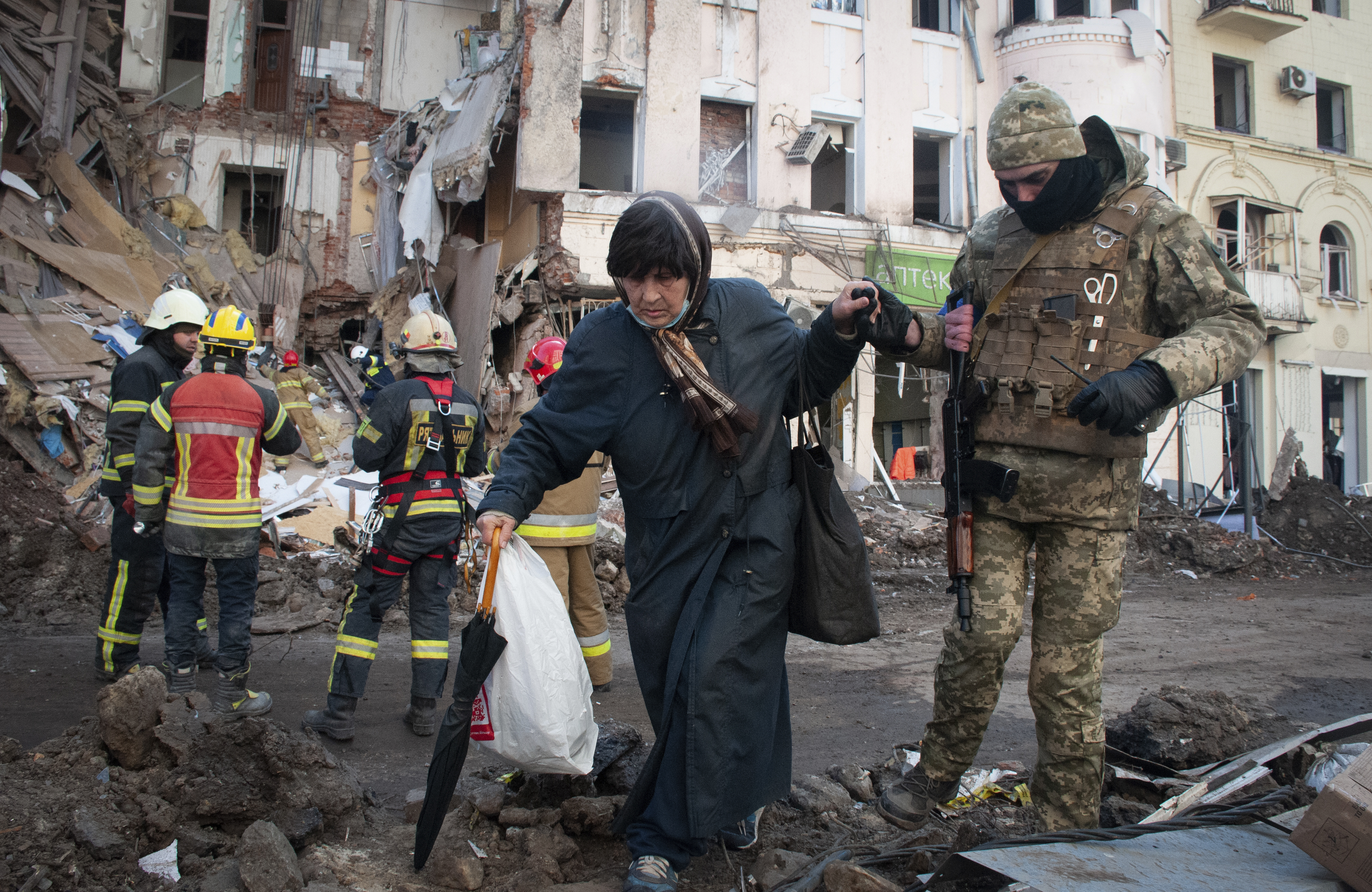 A volunteer of the Ukrainian Territorial Defense Forces assists a woman to cross the street in Kharkiv