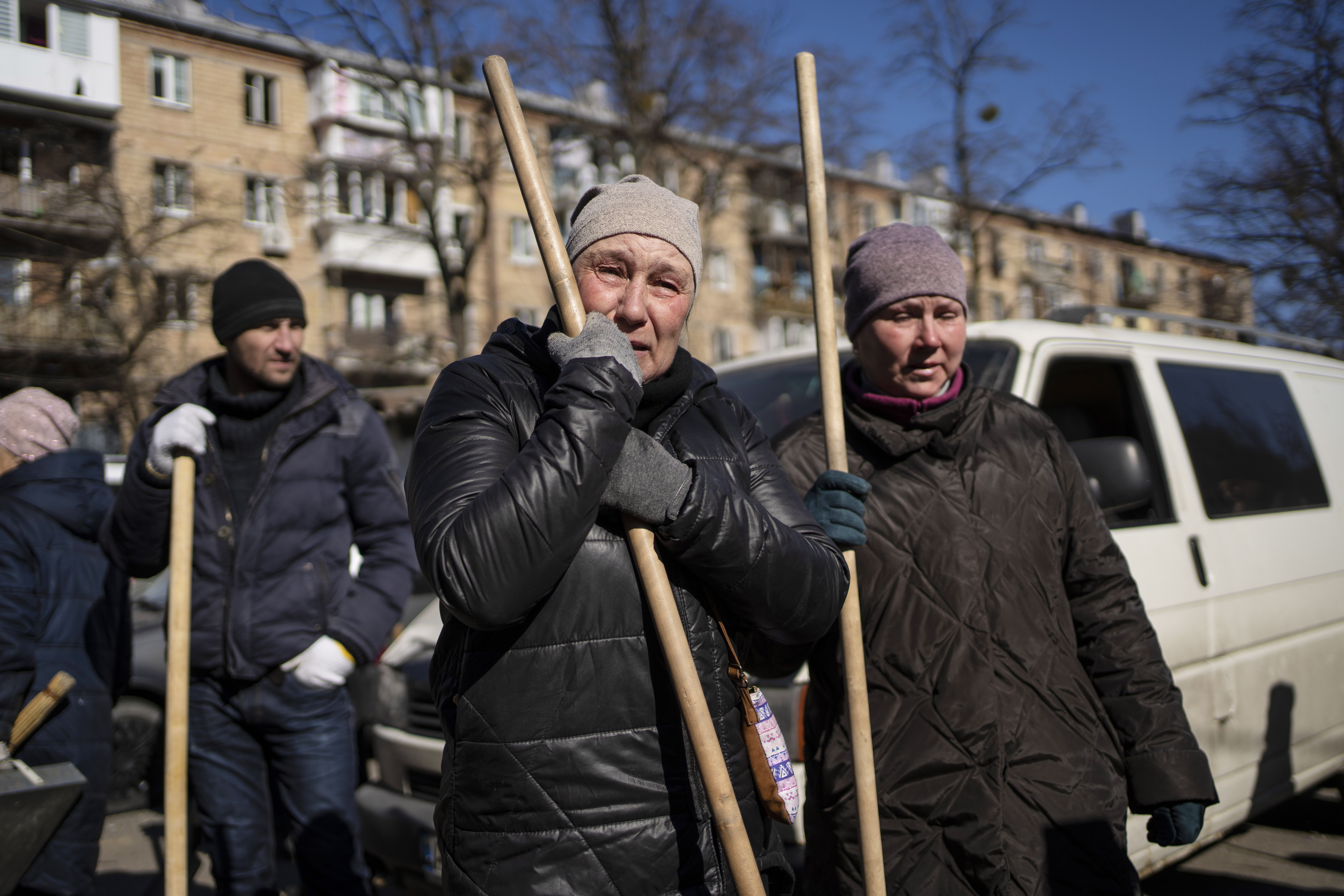 A woman cries before starting to clean the site where a bombing damaged residential buildings in Kyiv