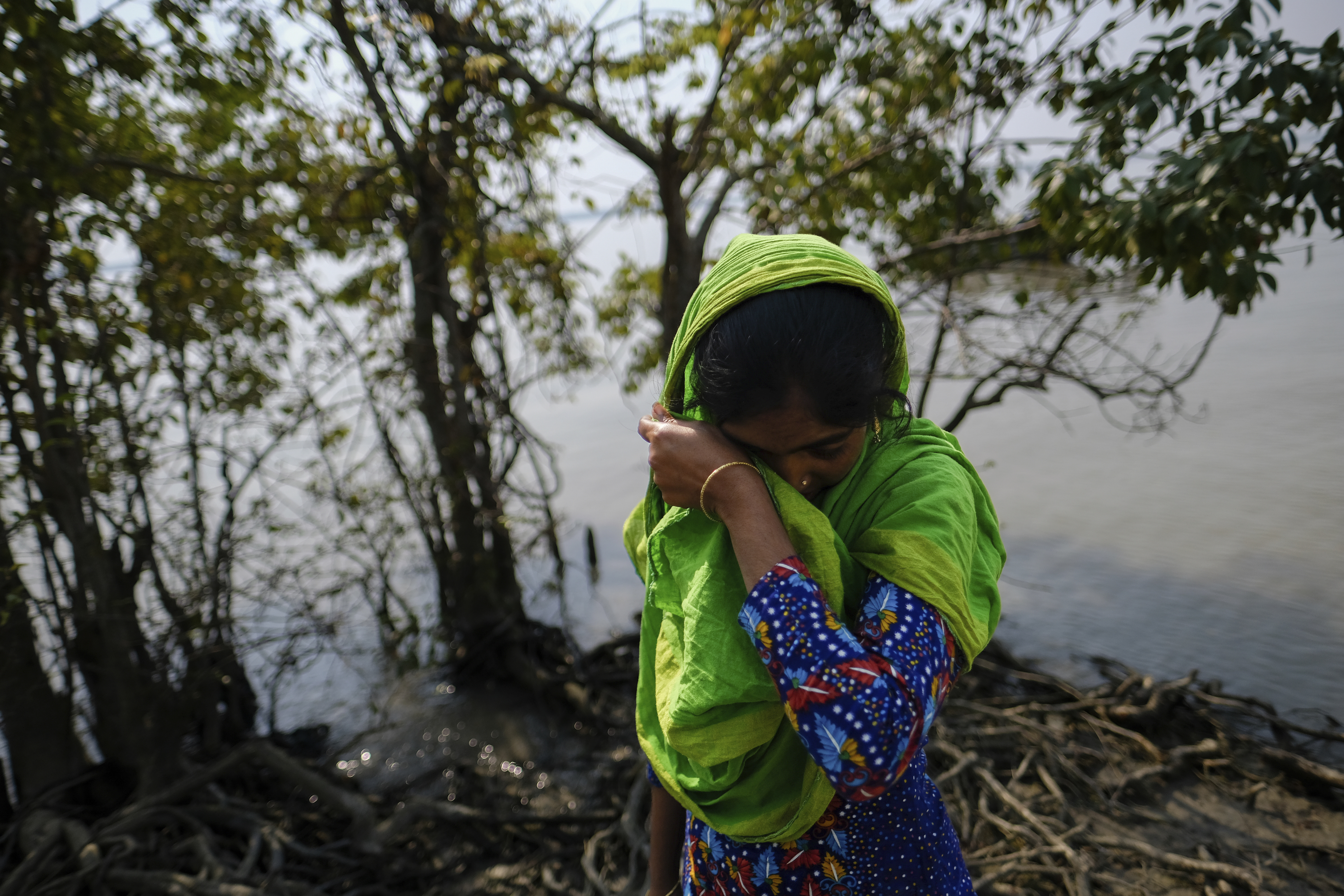 Reshma Begum, 28, wipes her tears as she stands on her lost land
