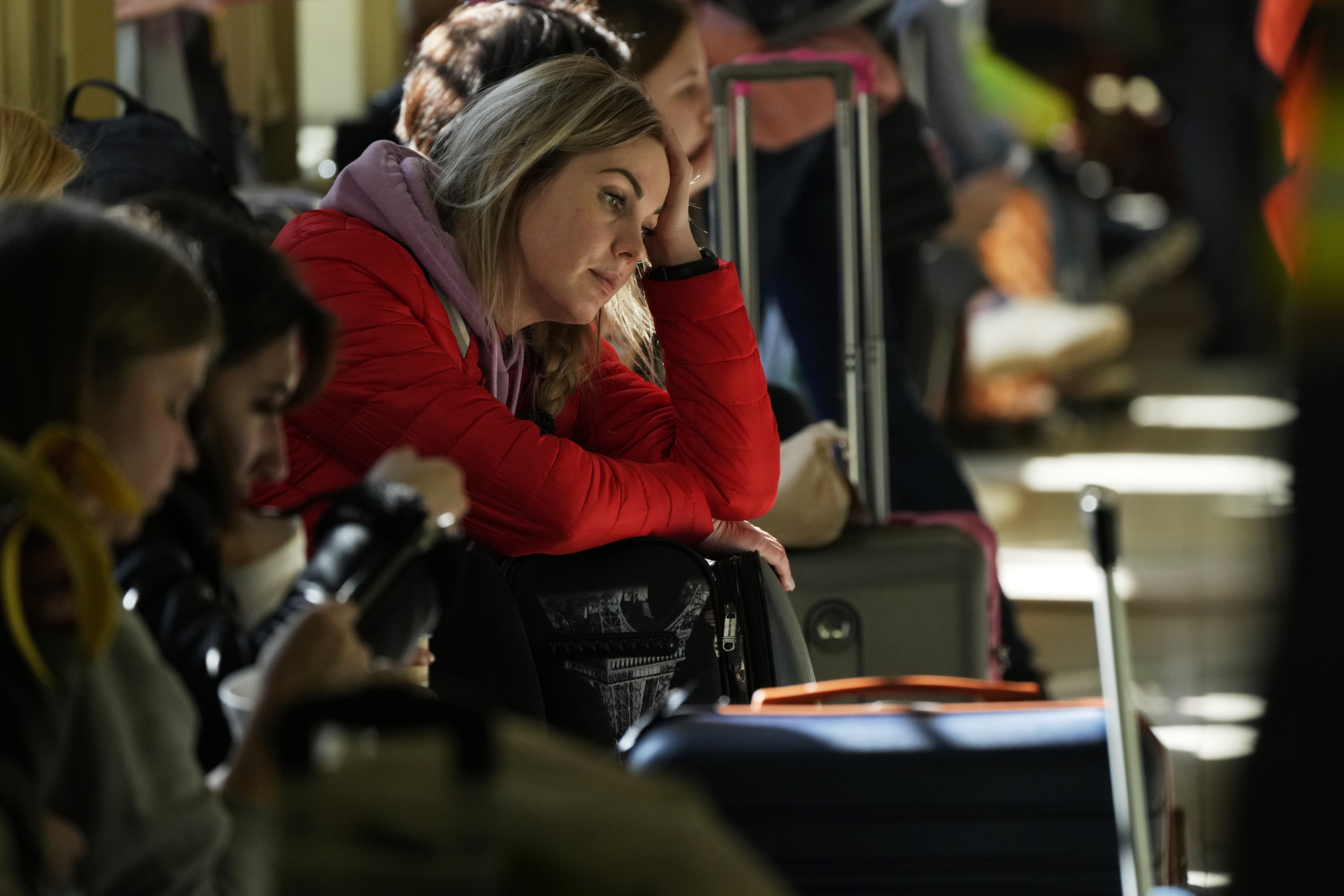A woman waits for a transport after fleeing the war from neighboring Ukraine at a railway station in Przemysl, Poland