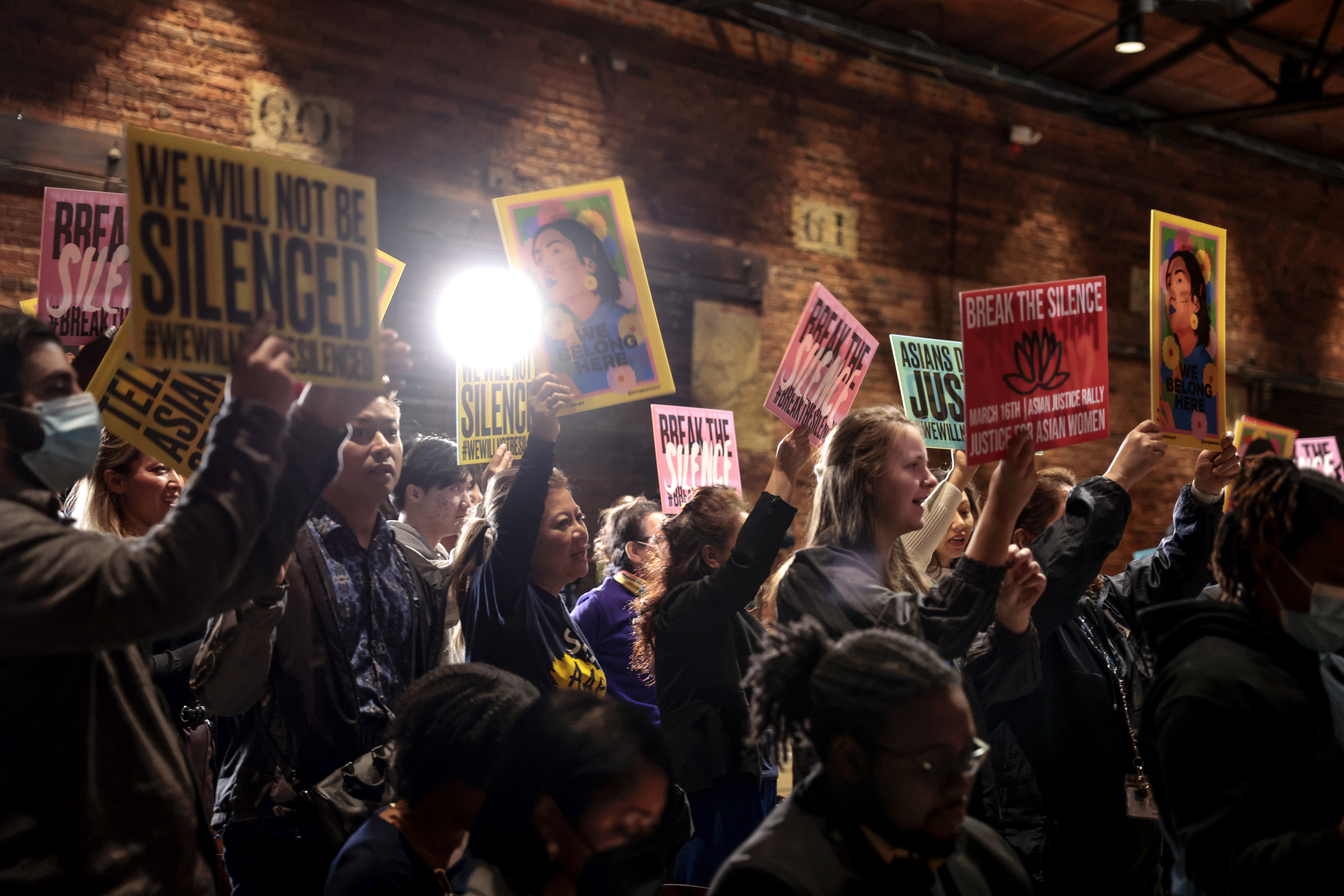Attendees hold up signs as they during “The Asian Justice Rally – Break the Silence” event at the Georgia Railroad Freight Depot on March 16, 2022 in Atlanta, Georgia.