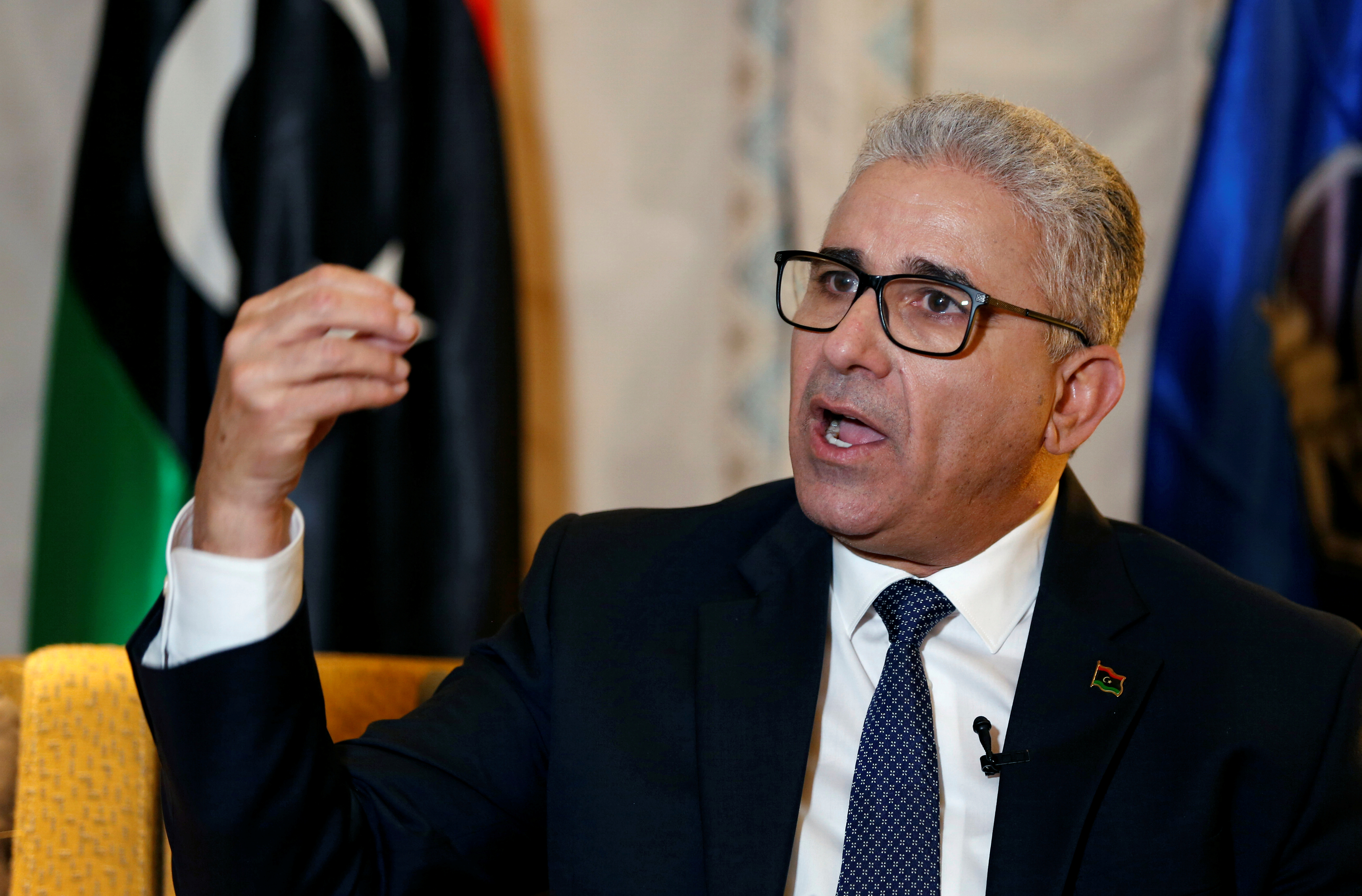 Fathi Bashagha speaks with a Libyan flag on the background.