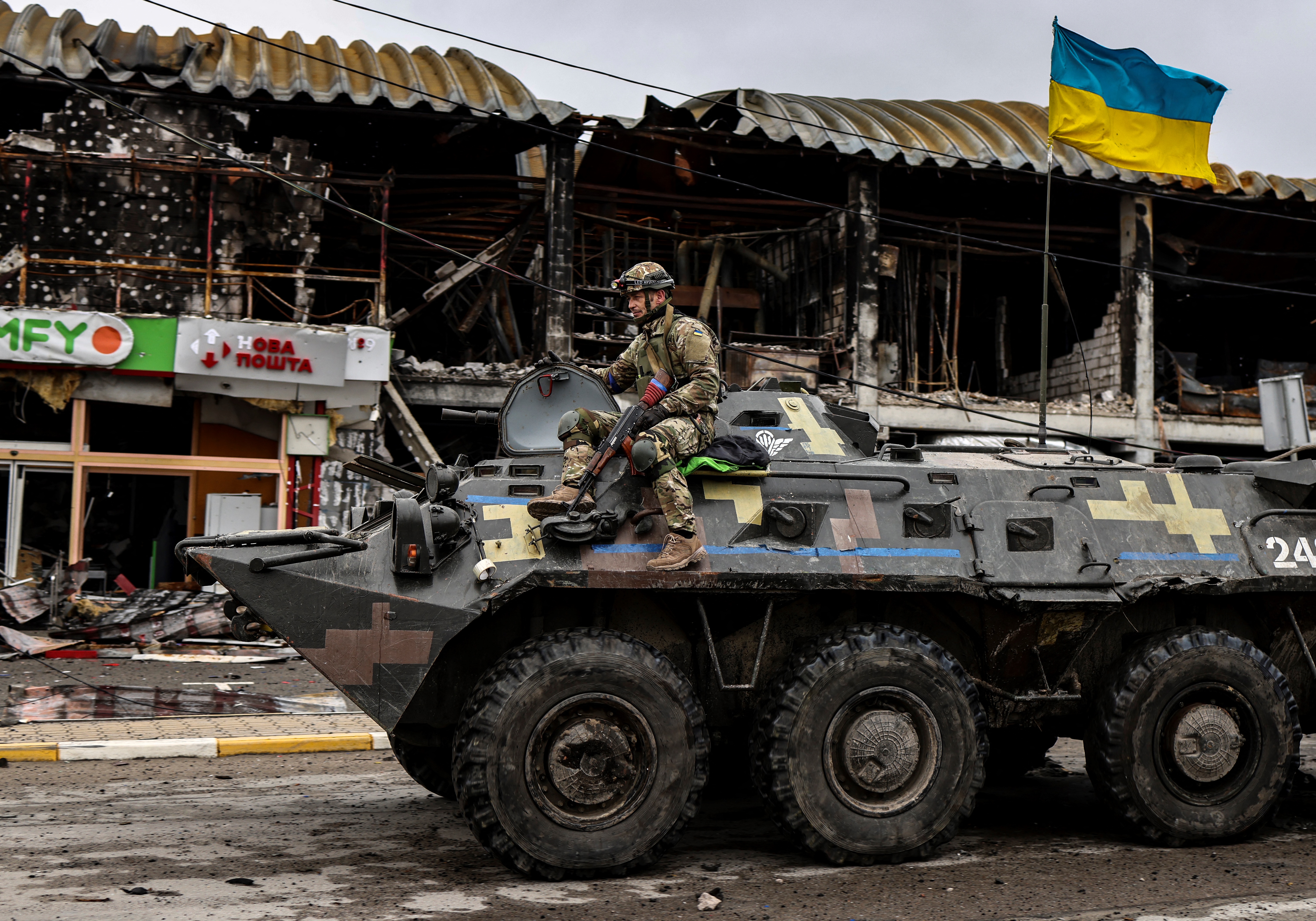 A Ukranian soldier patrols in an armoured vehicle a street in Bucha, northwest of Kyiv