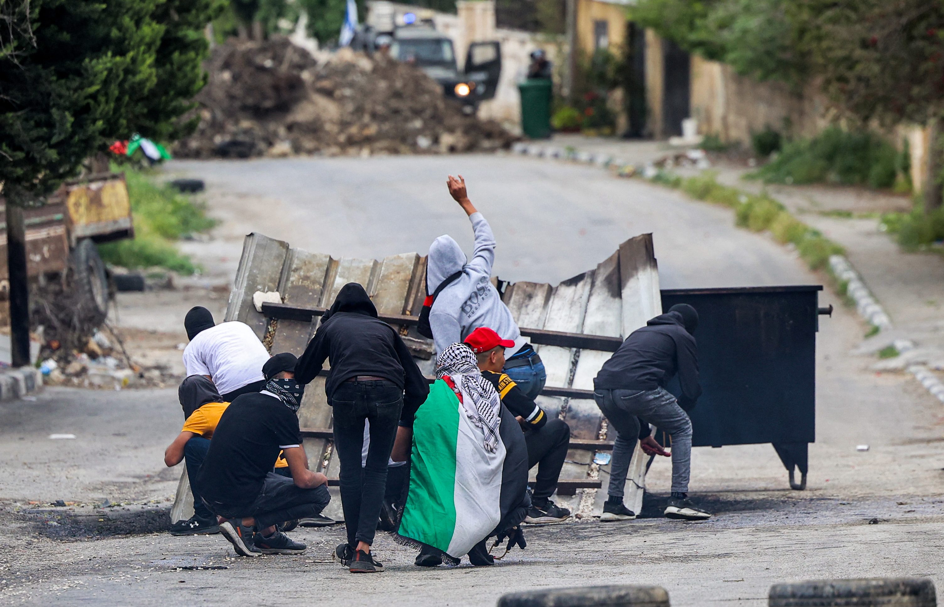 Palestinian protesters throw stones at Israeli forces during clashes in the village of Burqa in the north of the occupied West Bank