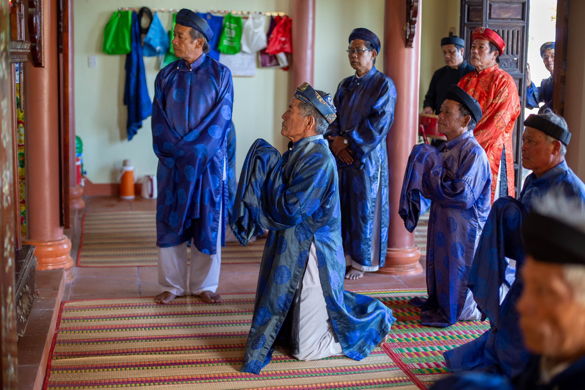 A photo of whale worshippers bowing and praying during a ceremony.