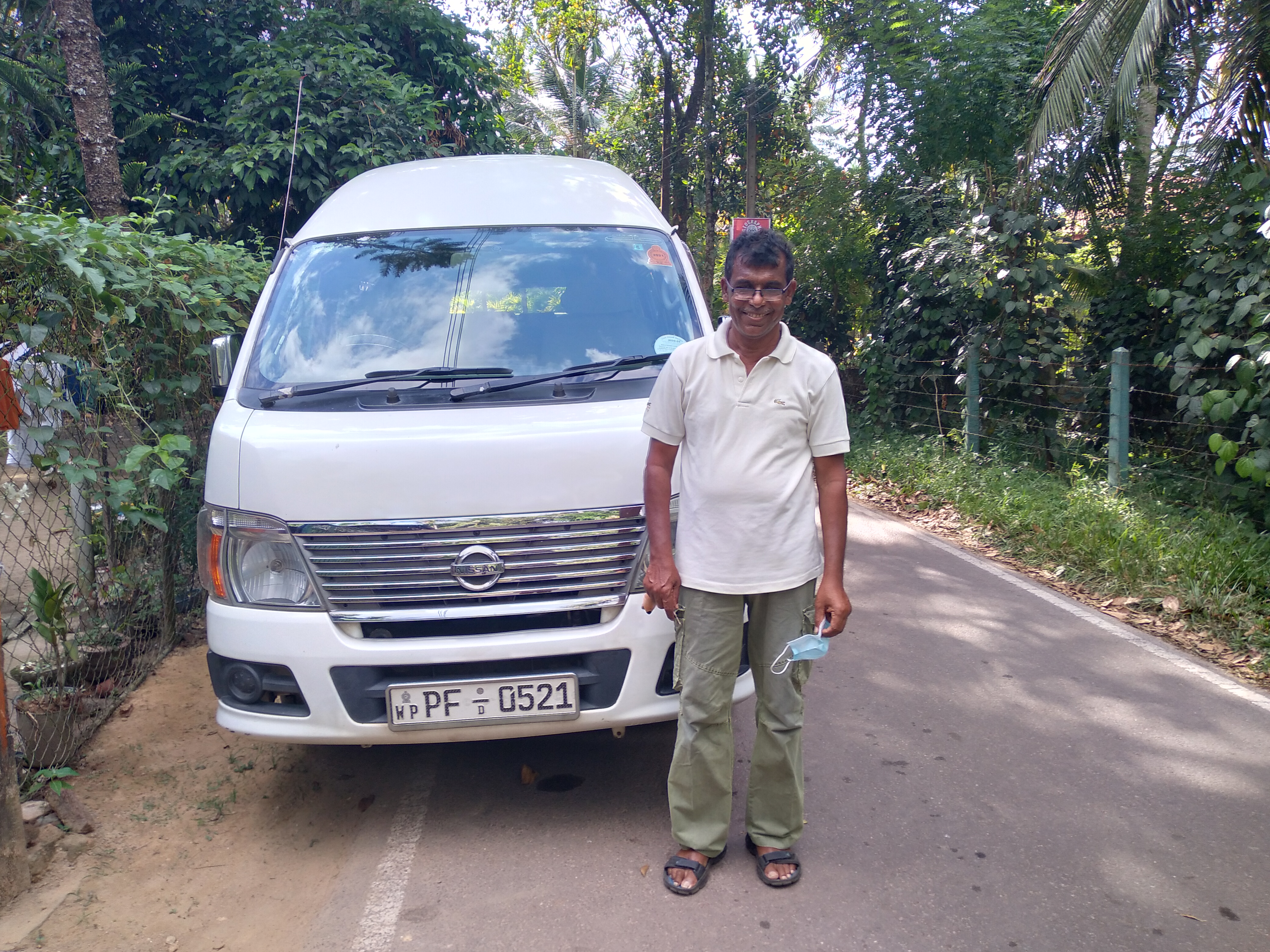 A man stands in front of a vehicle