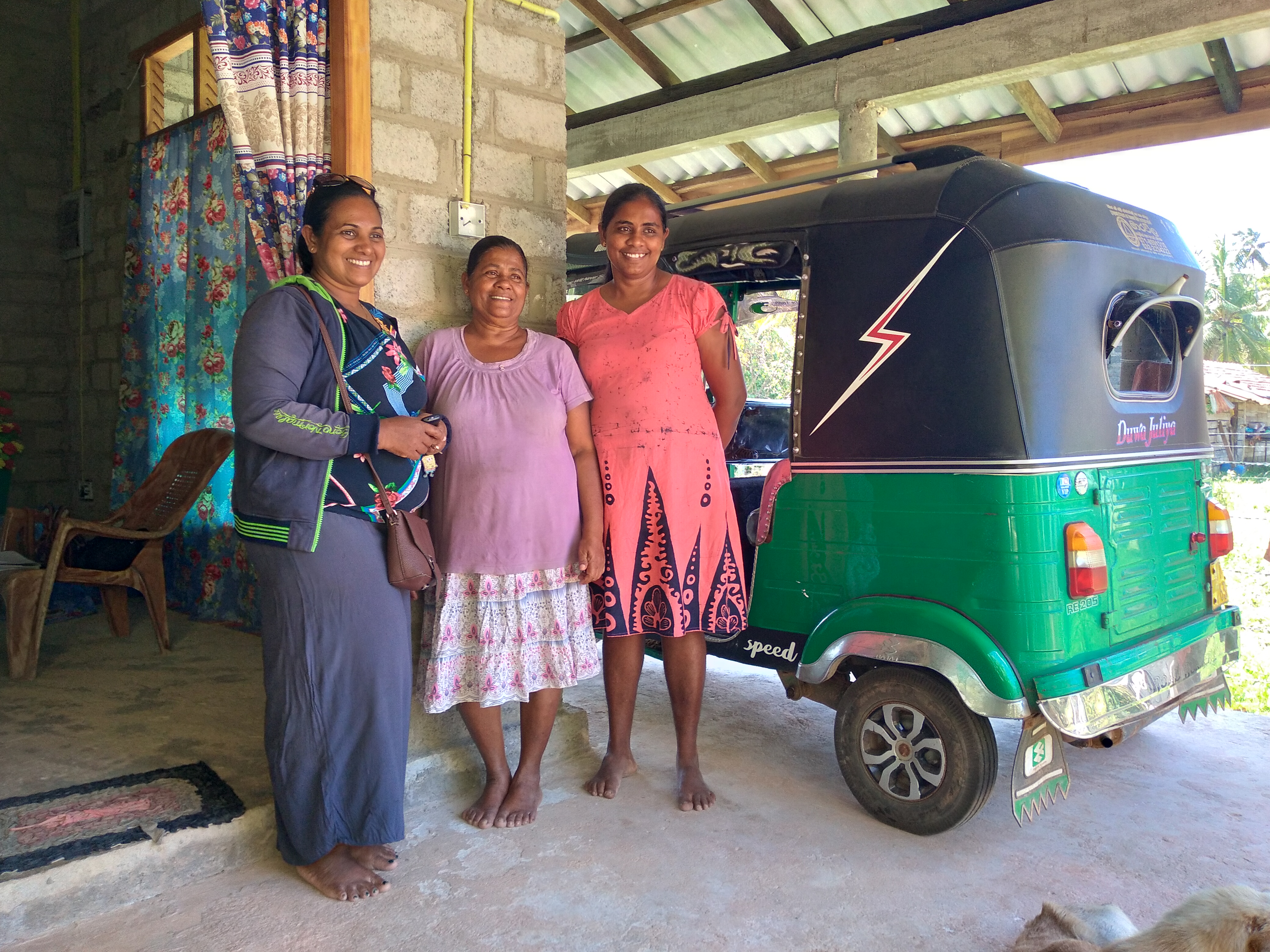 Women stand next to a vehicle