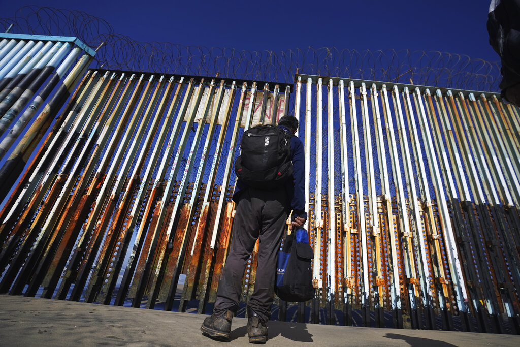 A migrant waits of the Mexican side of the border