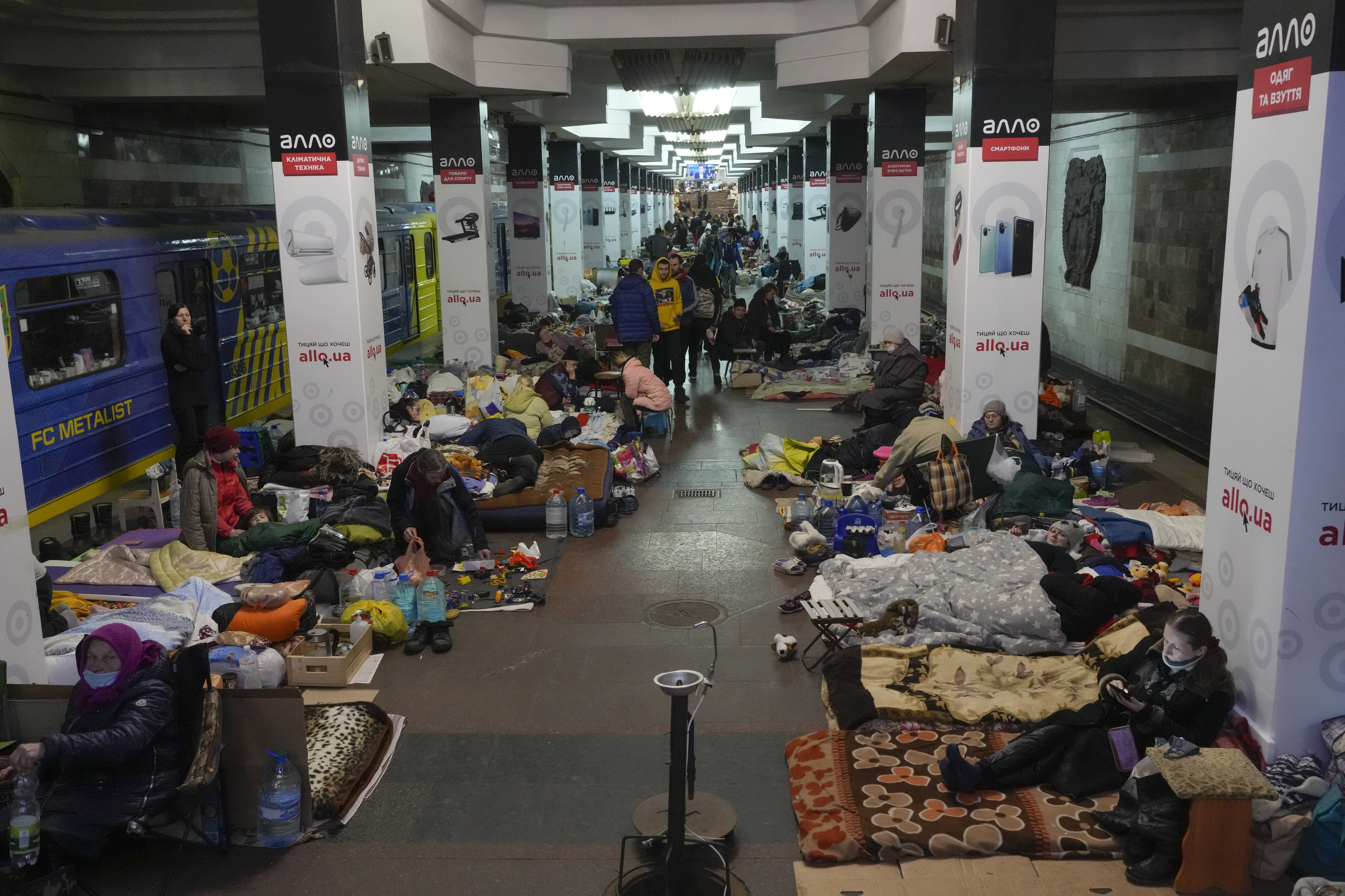 People with their belongings in a city subway that they have used as a bomb shelter in Kharkiv, Ukraine, Thursday, March 24, 2022. World leaders heard impassioned pleas Thursday from Ukrainian President Volodymyr Zelenskyy for more military aid to defend his country and the United States announced new sanctions and humanitarian aid as officials gathered for a trio of summits to discuss next steps in countering Russia's month-old invasion of its much smaller neighbor. (AP Photo/Efrem Lukatsky)