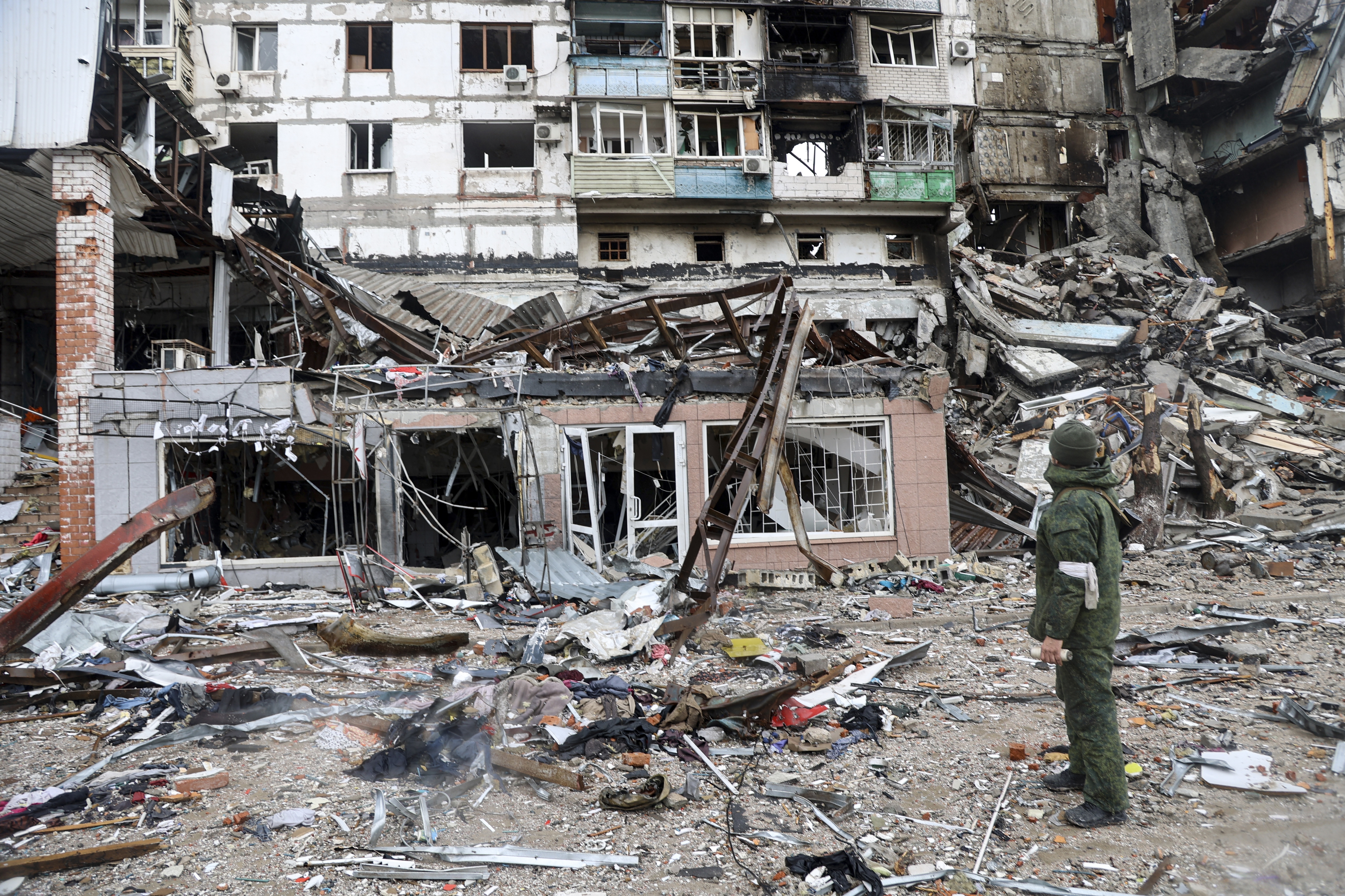 A serviceman stands at a building damaged during fighting in Mariupol, on the territory which is now under the Government of the Donetsk People's Republic control, eastern in Mariupol