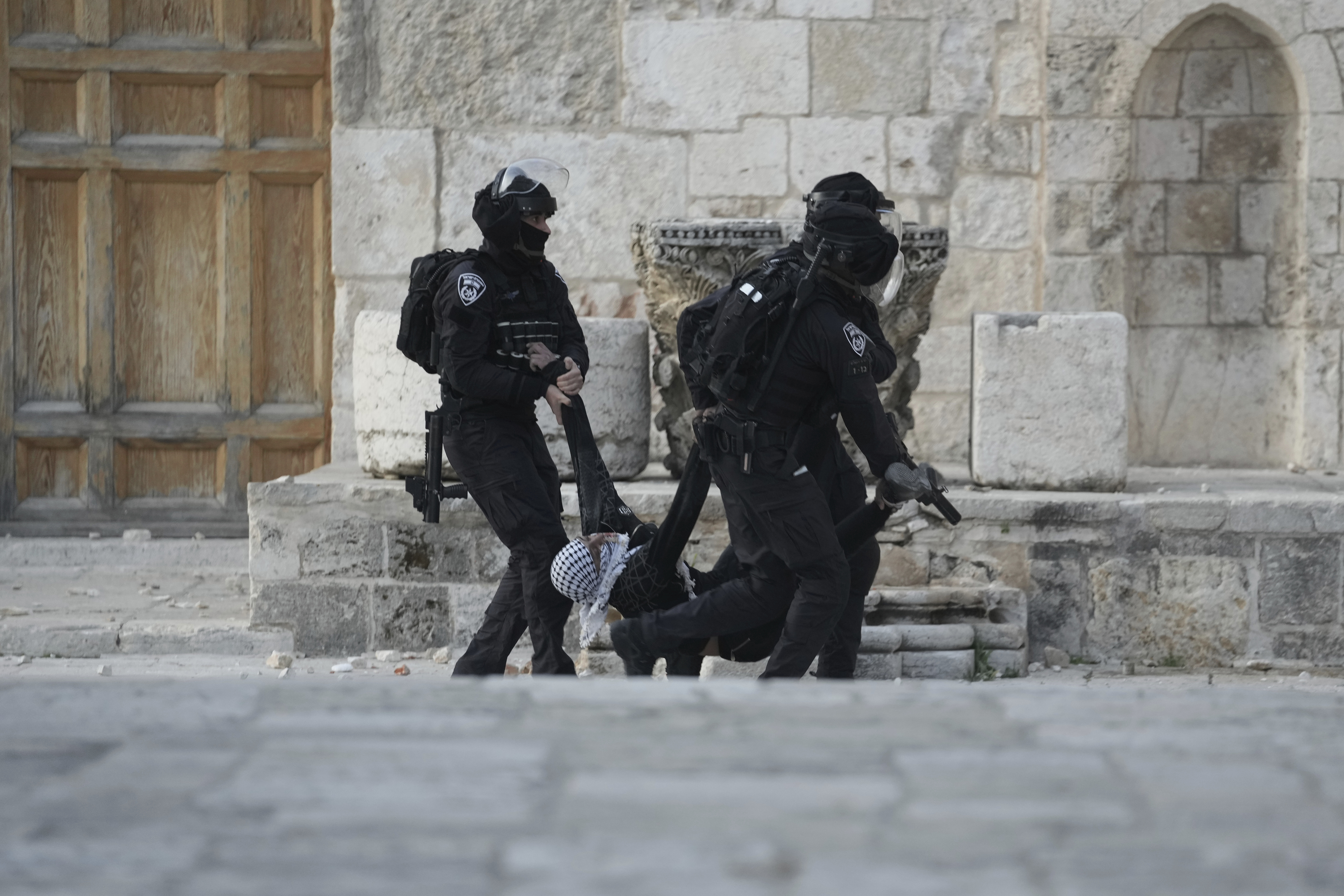 Israeli police carry a Palestinian protester during clashes at the Al Aqsa Mosque compound