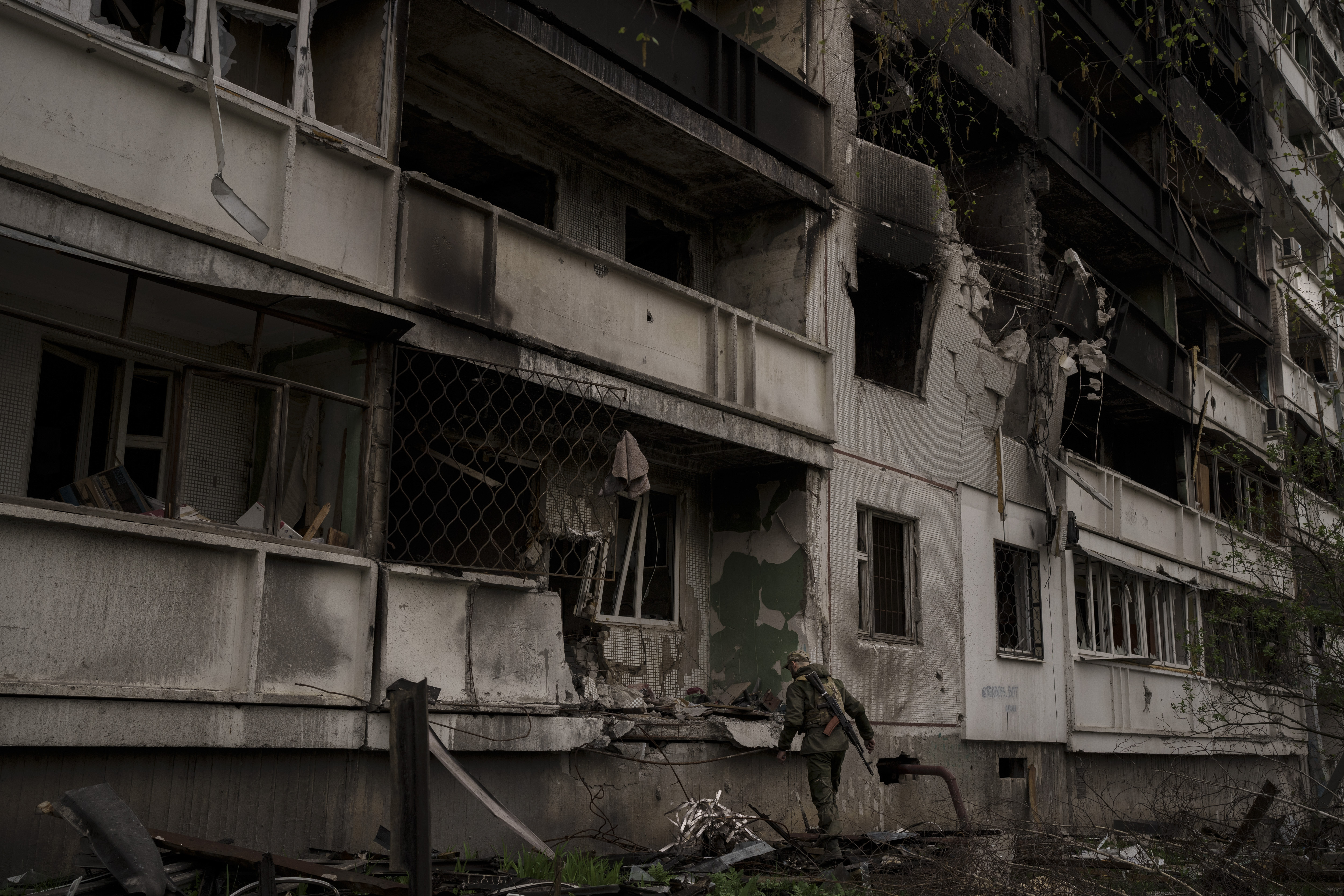 A Ukrainian service member inspects a heavily damaged apartment building after Russian bombardment in Kharkiv, Ukraine.