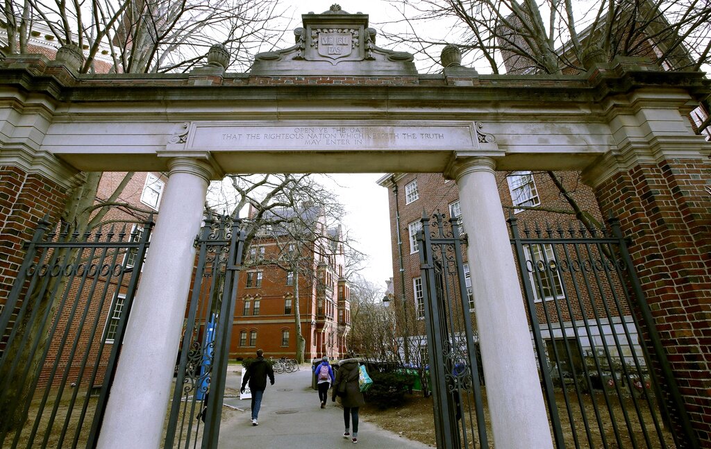 file photo, a gate opens to the Harvard University campus in Cambridge, Mass.