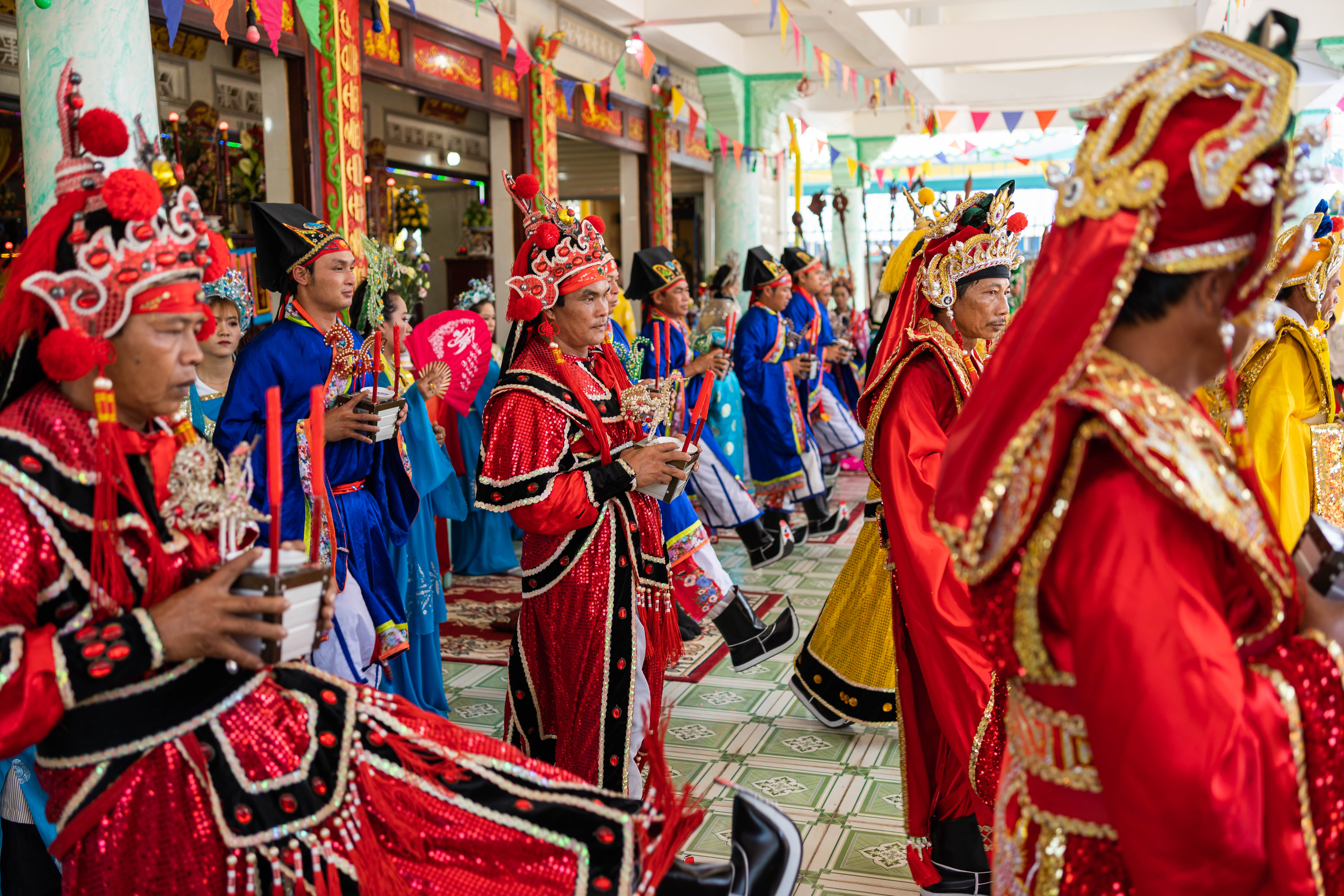 A photo of whale worshippers in elaborate dress carrying candles and flowers as part of a co-ordinated ritual during Phuoc Hai’s whale worship festival.