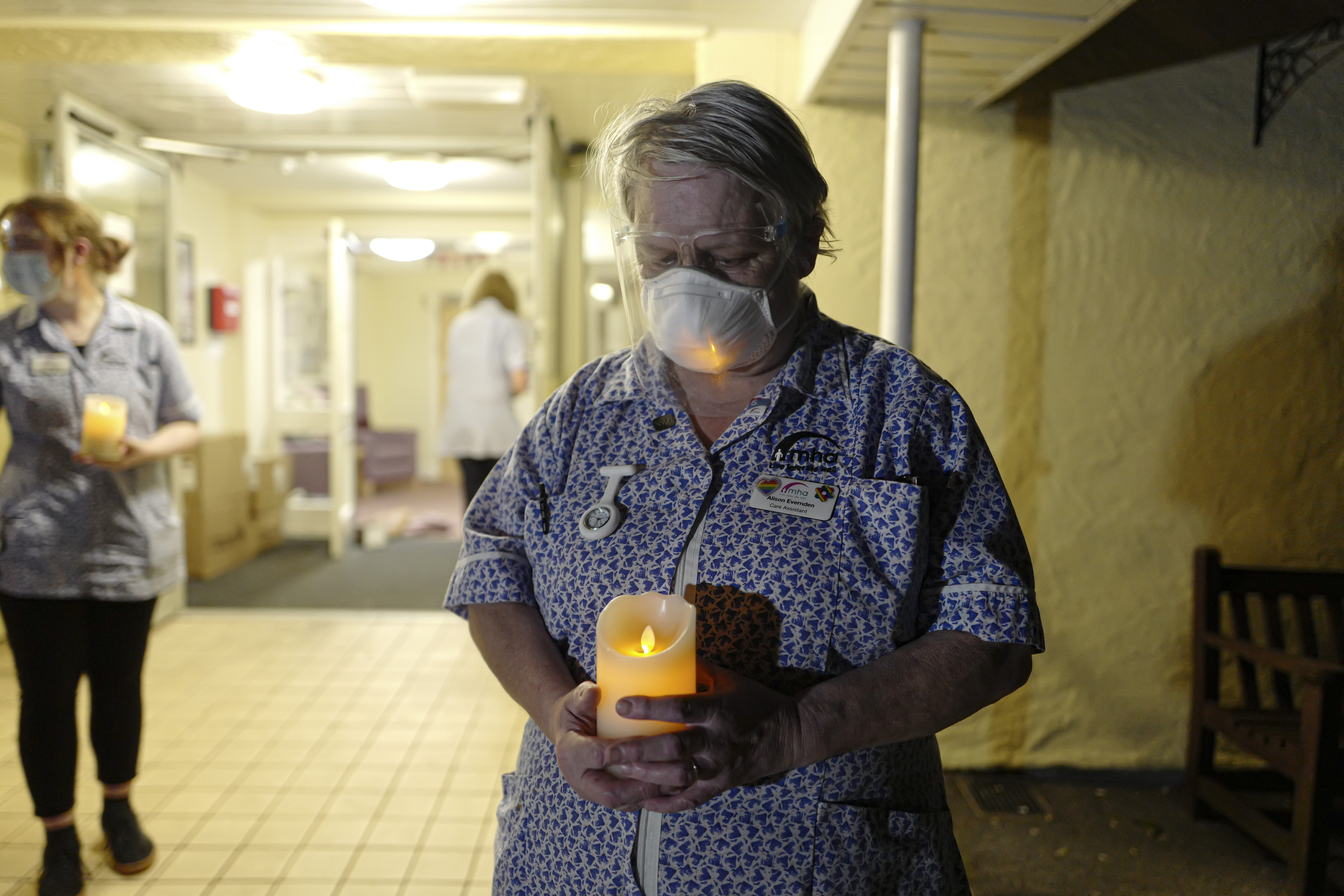 A nurse in uniform seen holding a candle