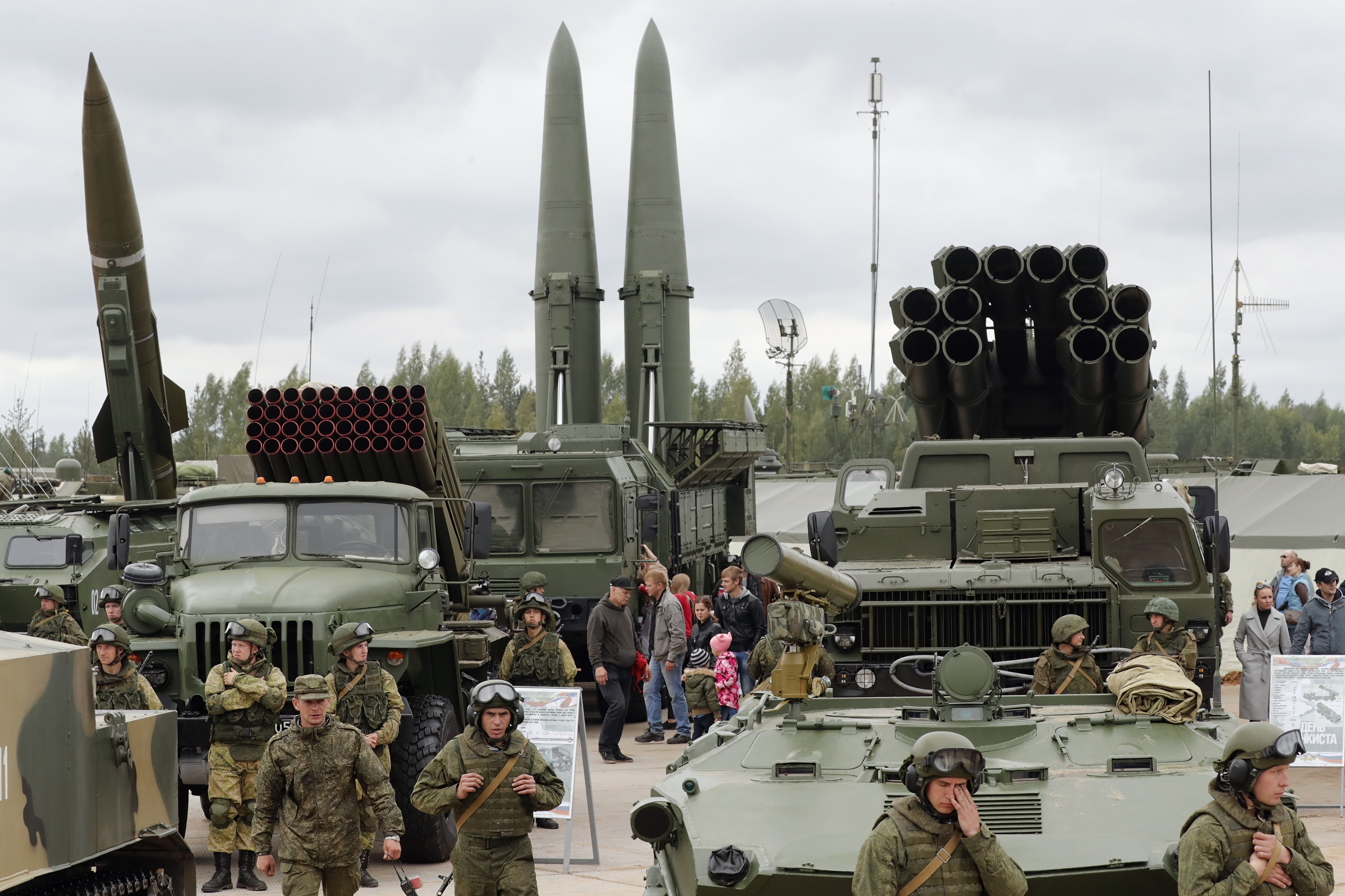 Visitors look at Russian tactical ballistic missiles and multiple rocket launcher during a military exhibition
