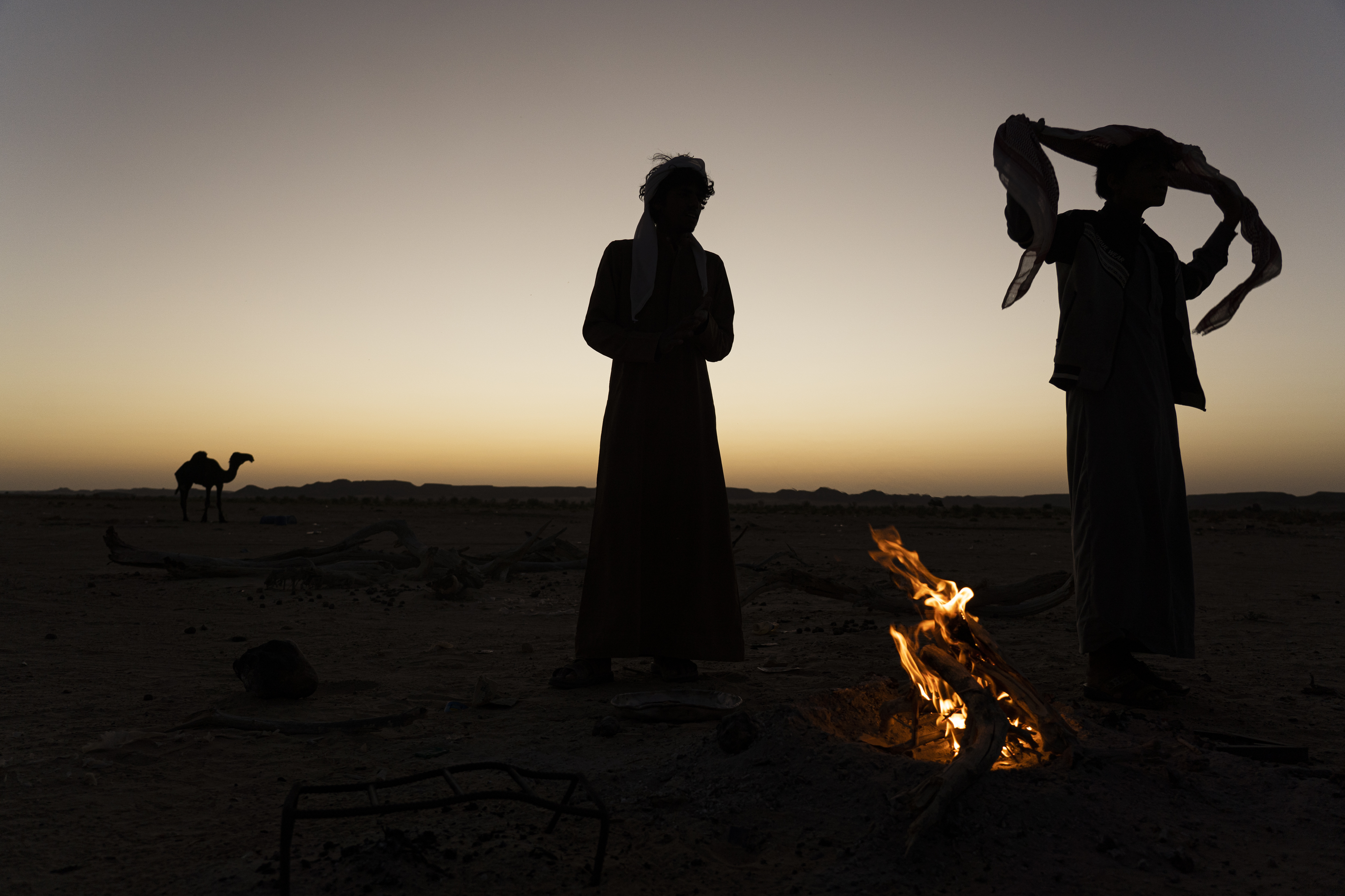 Bedouin men stand around a campfire between Rumah and the "Empty Quarter"