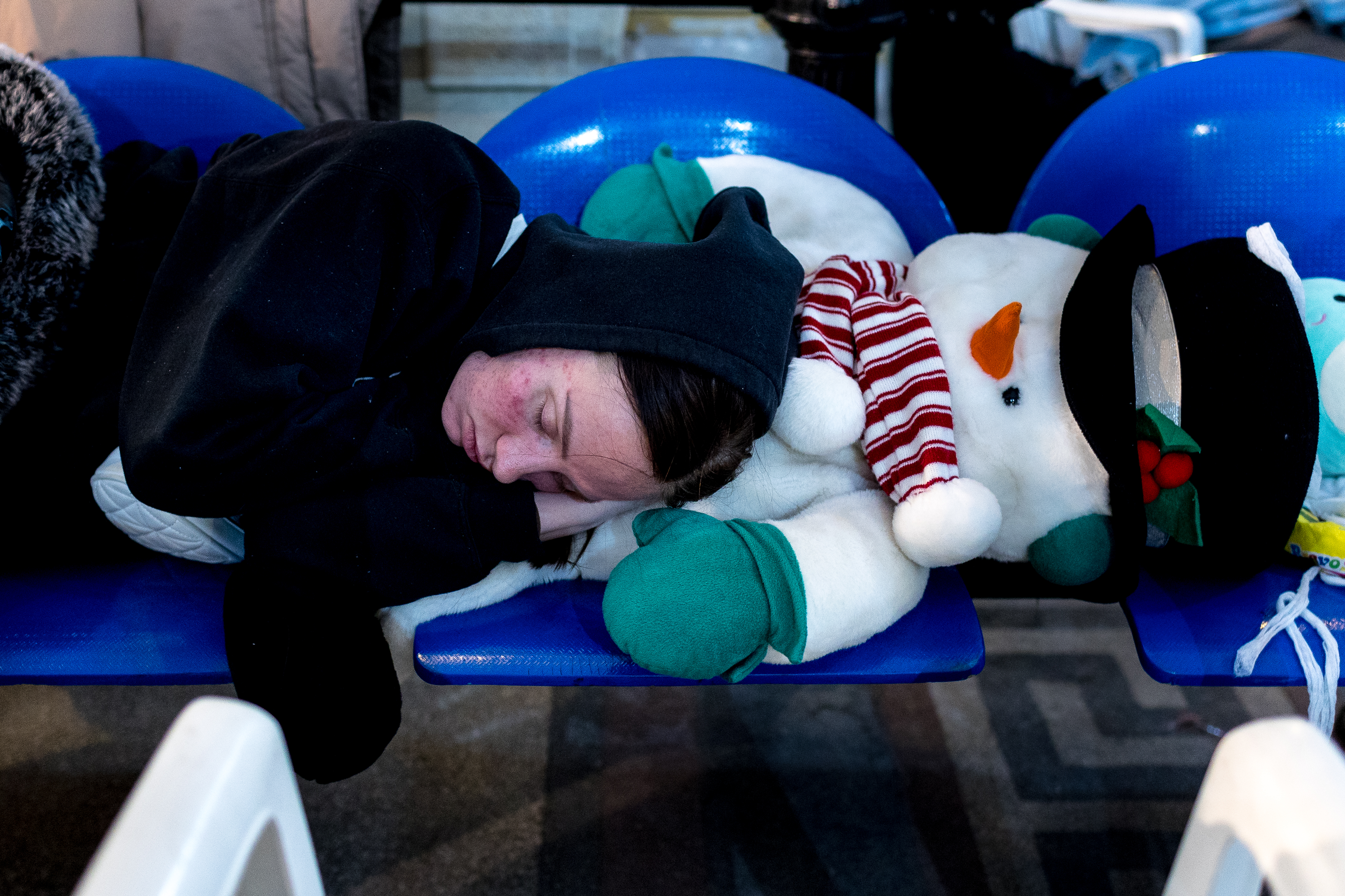 A person sleeps in a train station