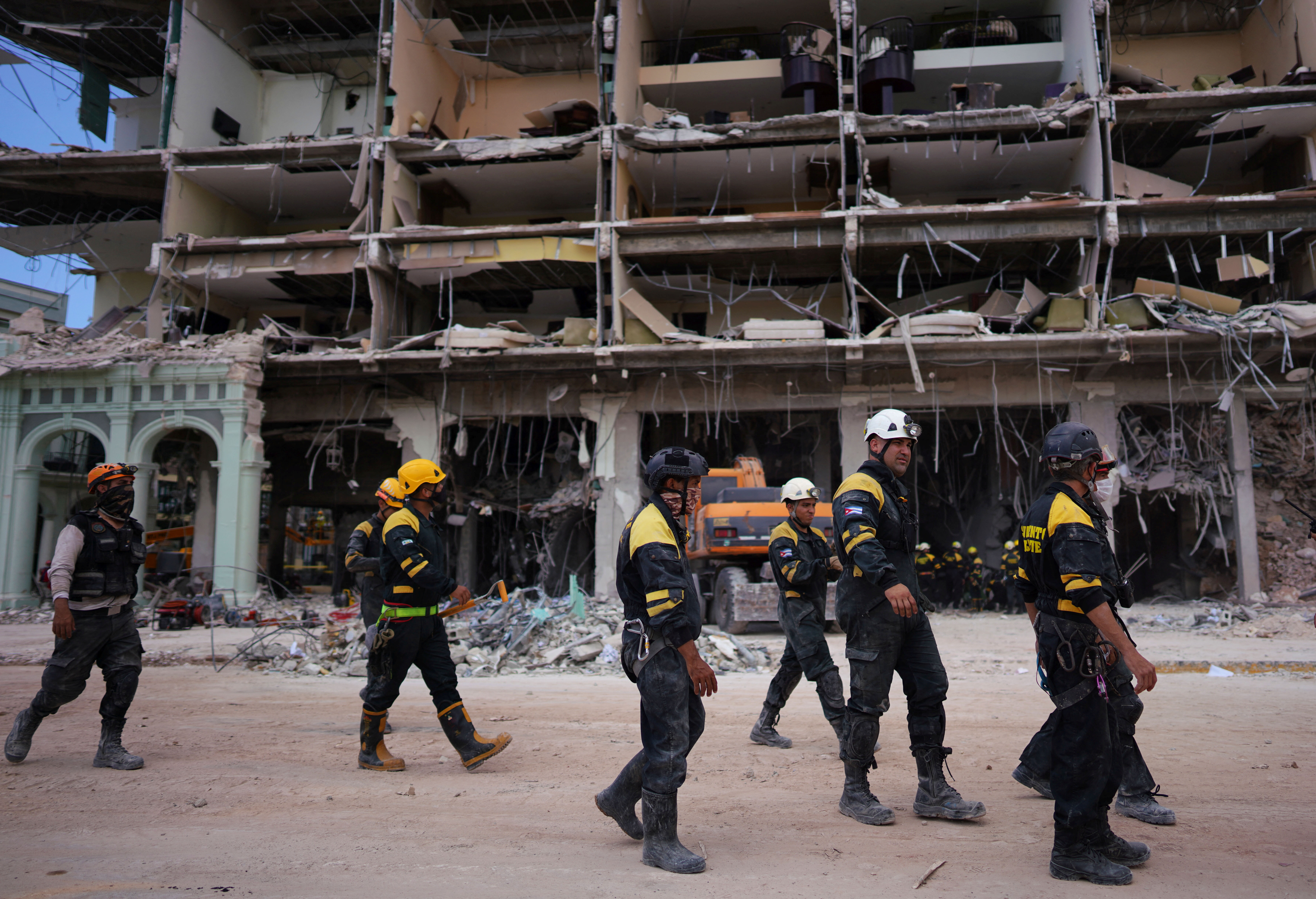 Rescue workers walk in front of the Saratoga Hotel in Havana, Cuba