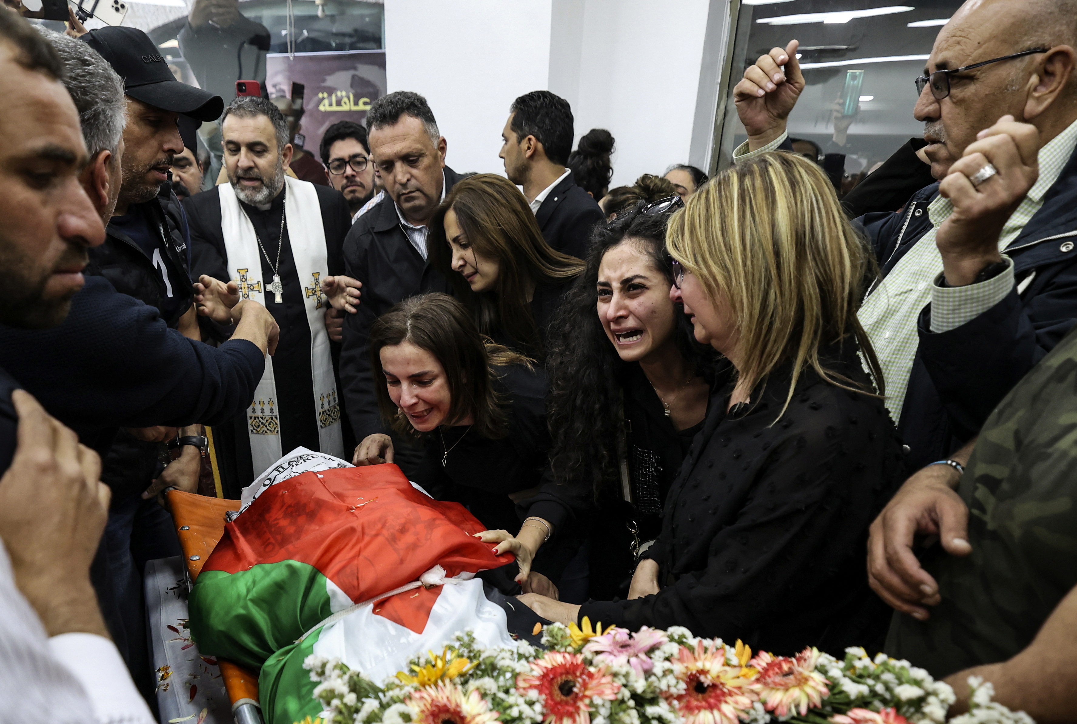 People react as the body of Al Jazeera reporter Shireen Abu Akleh.