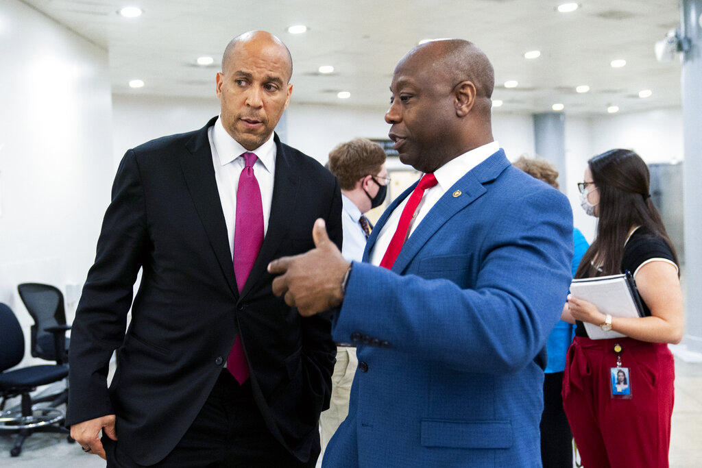 Senator Tim Scott, a Republican,  right, and Senator Cory Booker, a Democrat, talk as they wait for a Senate subway train on Capitol Hill in Washington, DC.,