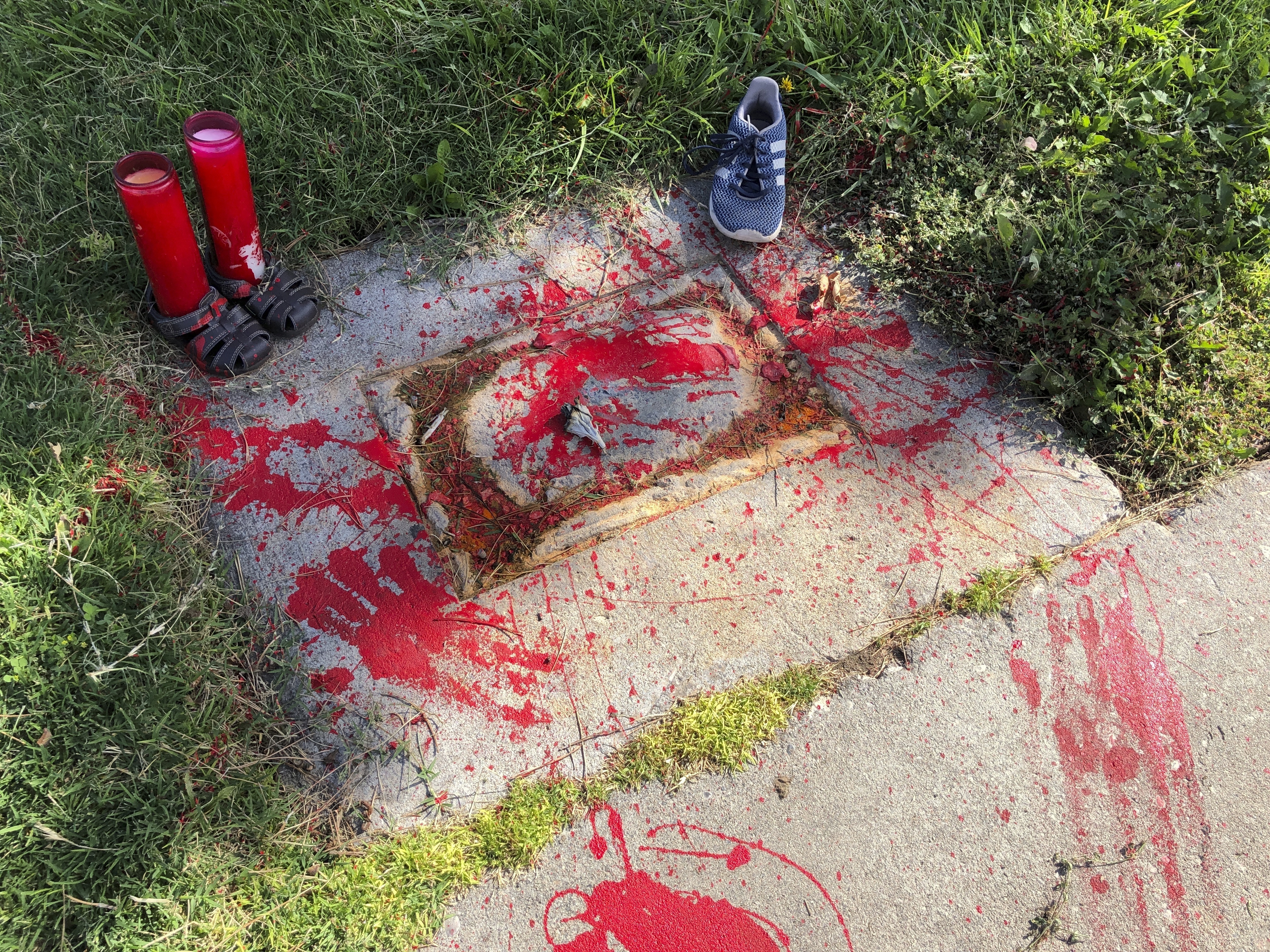 Red painted handprints cover the empty spot at a park in Albuquerque, New Mexico,