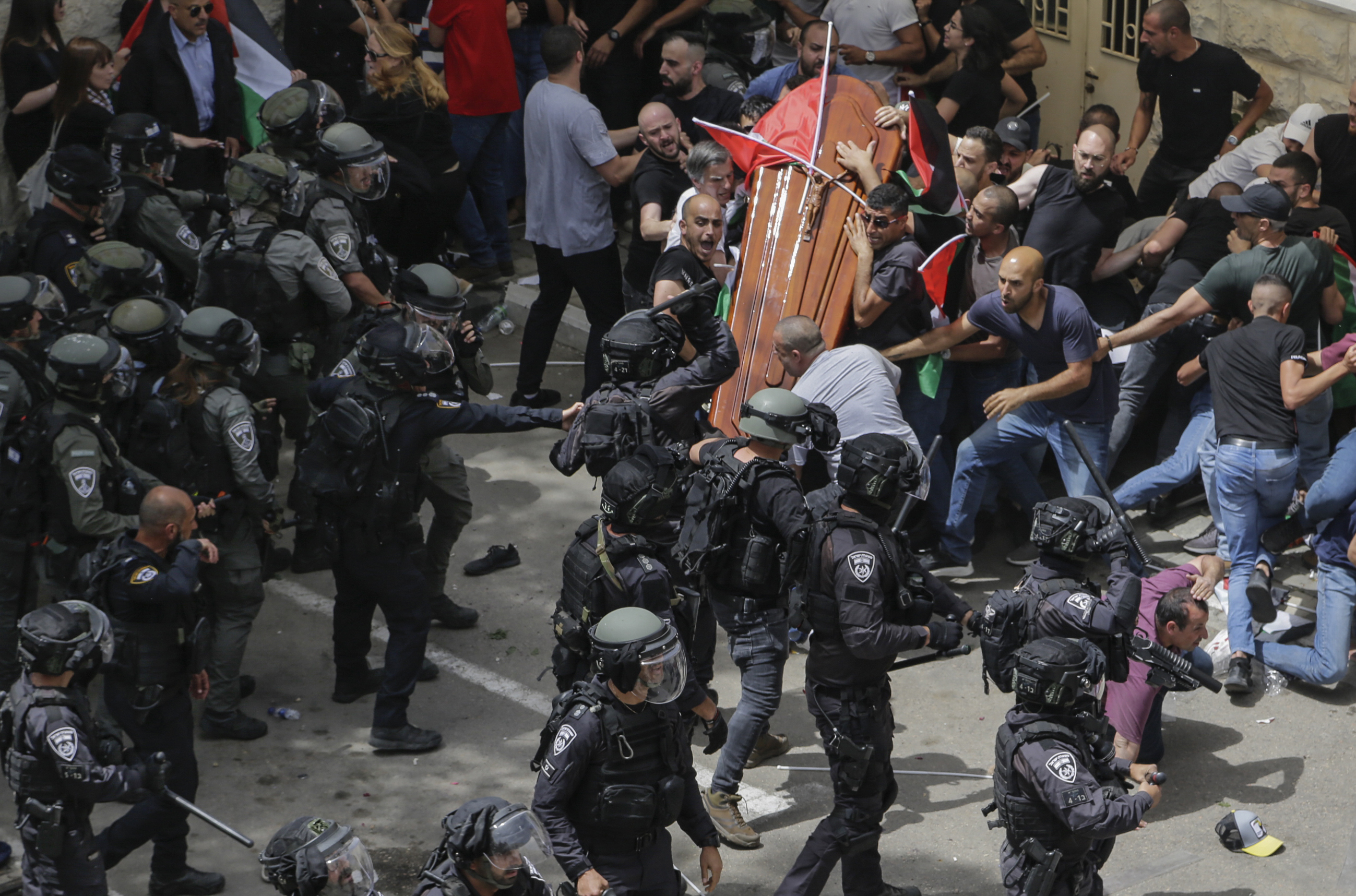 Israeli police confront mourners as they carry the casket of slain Al Jazeera veteran journalist Shireen Abu Akleh during her funeral in east Jerusalem