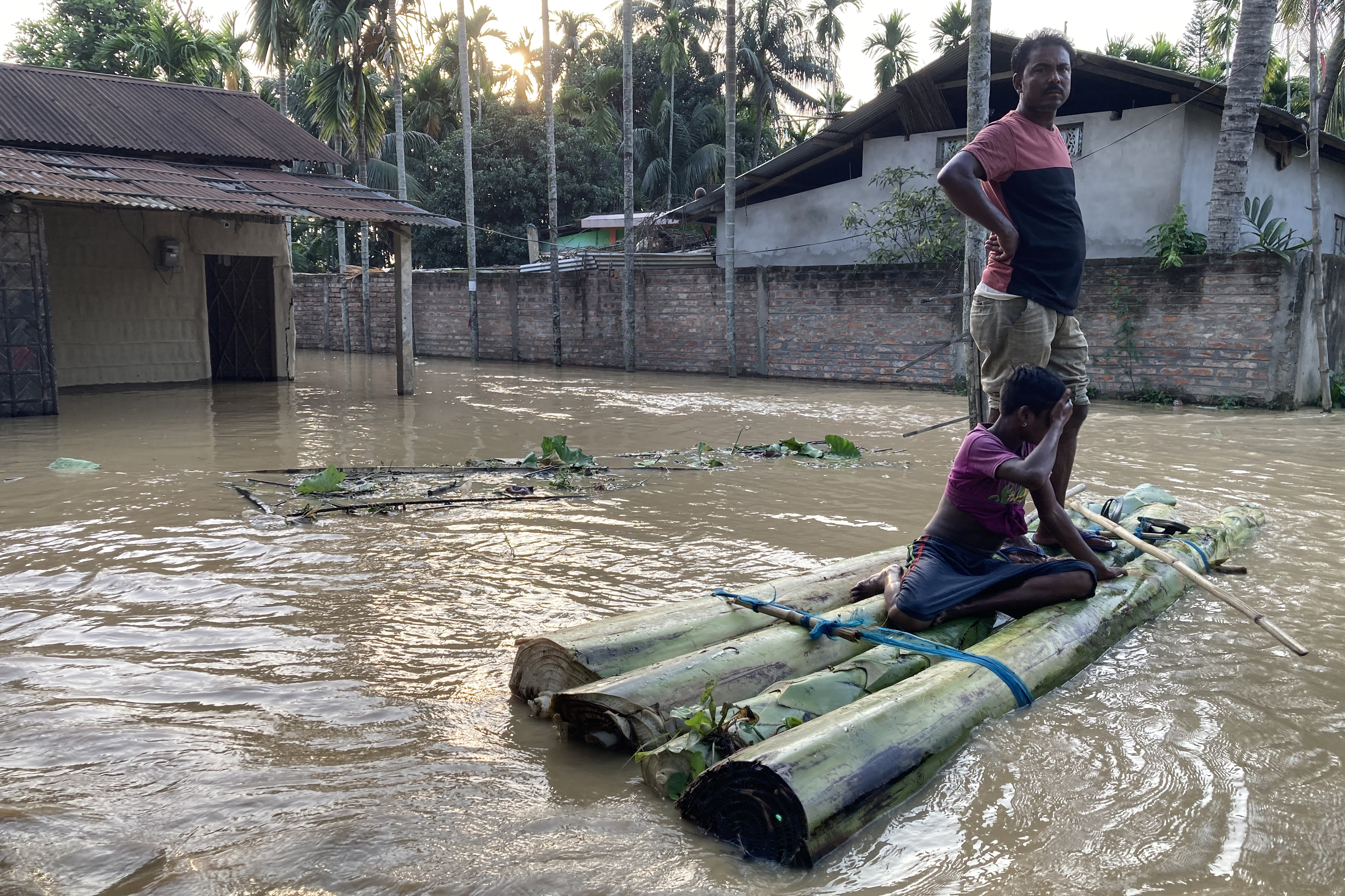 locals on a raft in Dighali Ati Village of Nagaon
