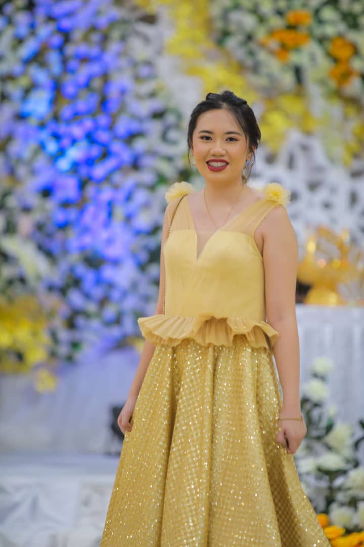 Jenifer Octavia Tjungmiady poses in a yellow dress with her hair tied up