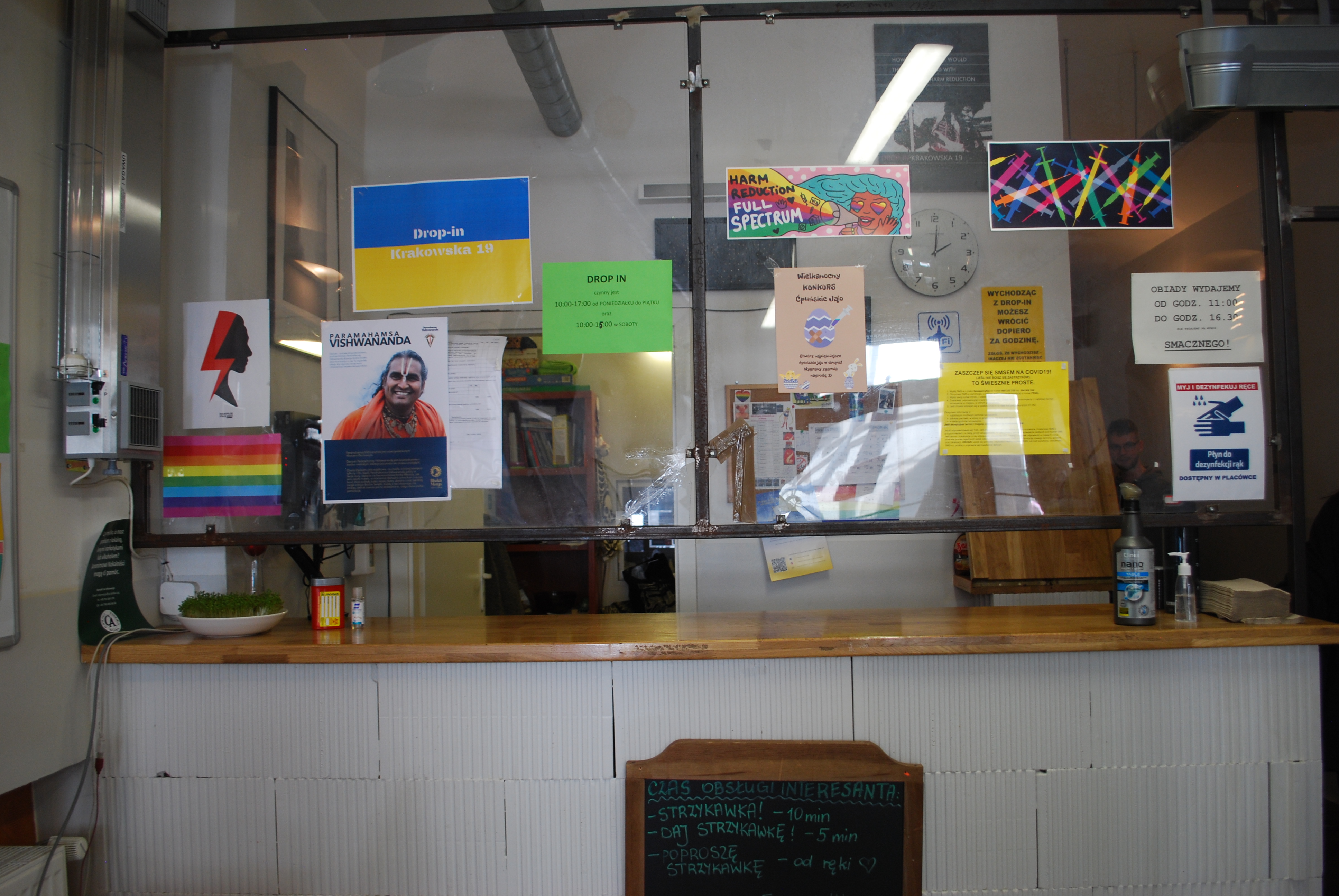 A photo of a window on top of a desk with photos and posters on the window.