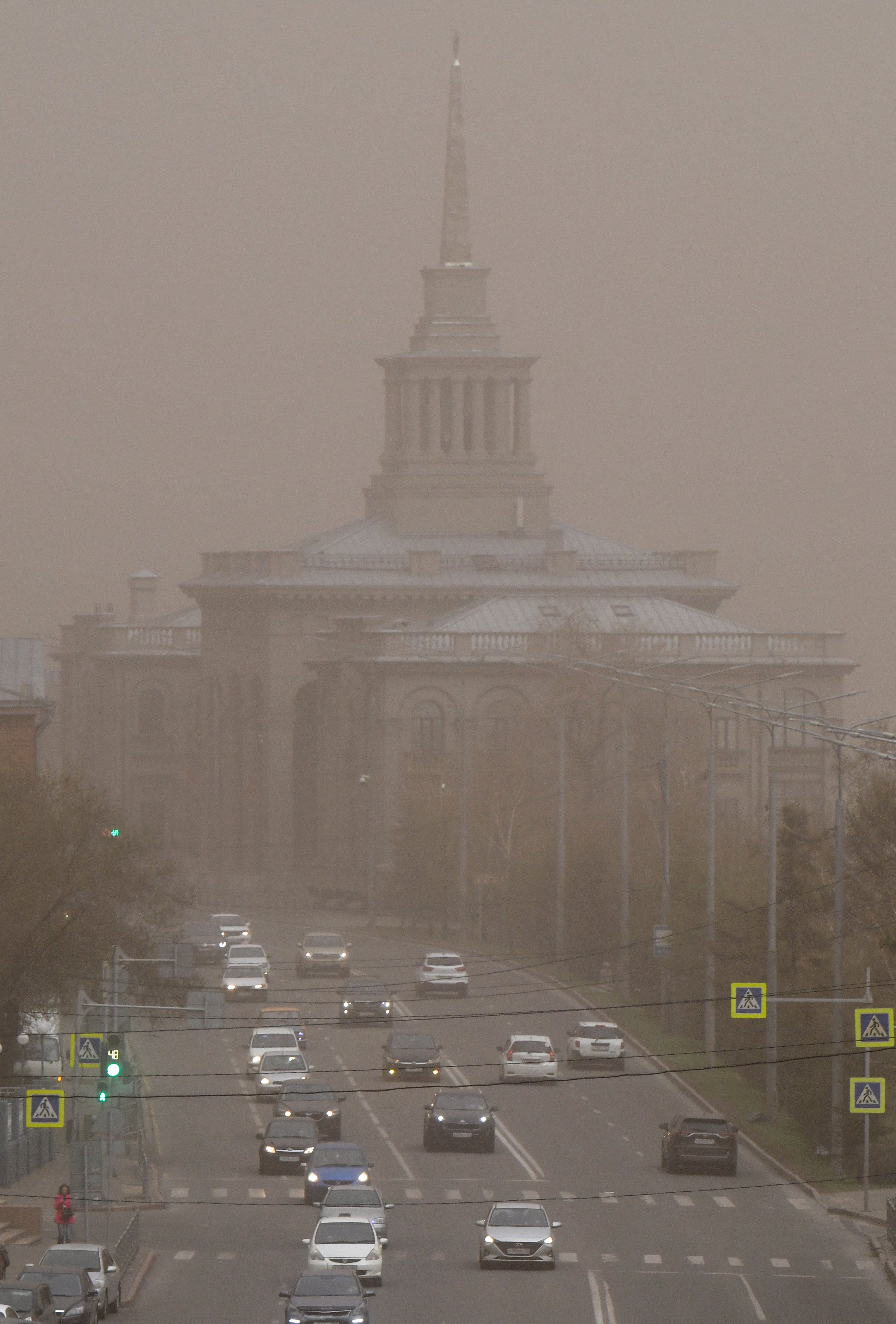 Vehicles drive along a road covered with smoke from wildfires in the Siberian city of Krasnoyarsk, Russia, May 7, 2022 [Alexander Manzyuk/Reuters]