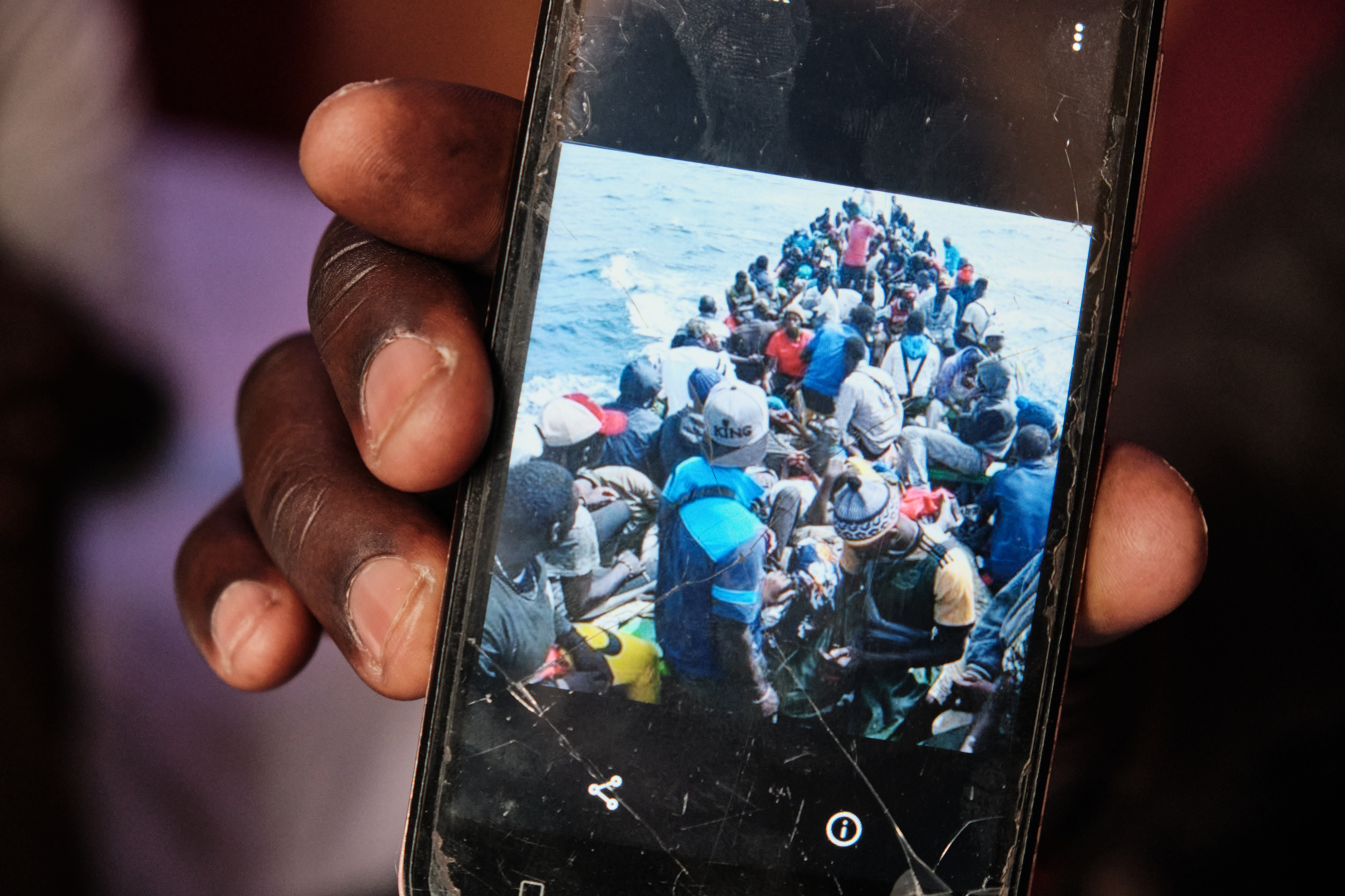 A photo of a person showing a cellphone photo taken during his six-day crossing to the Canary Islands with a small boat filled with people.