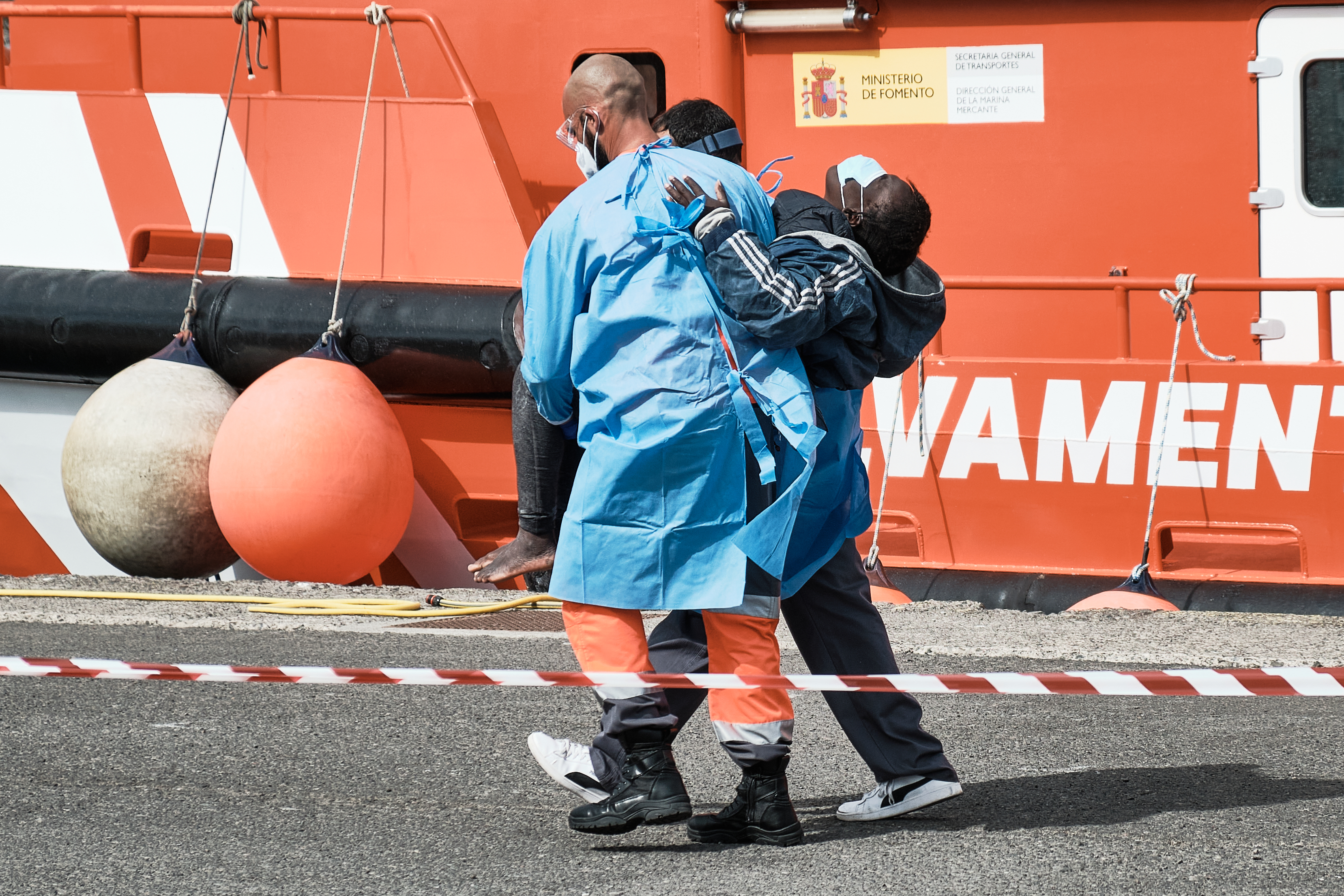 A photo of a woman being helped by Red Cross staff after a rescue vessel came ashore in Arguineguin, Gran Canaria.