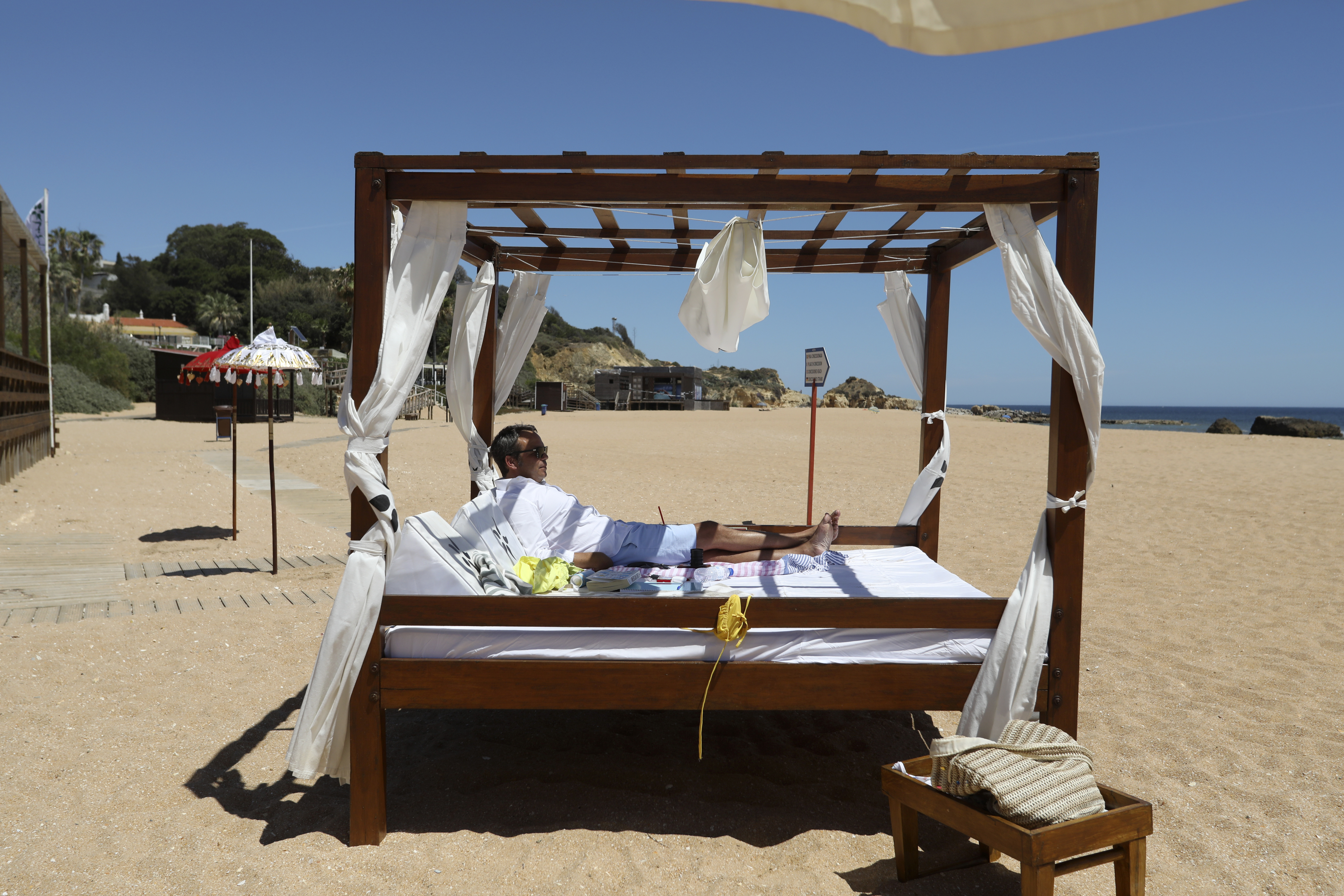 A Swiss tourist enjoys a nearly empty beach in Albufeira, in Portugal's southern Algarve region,
