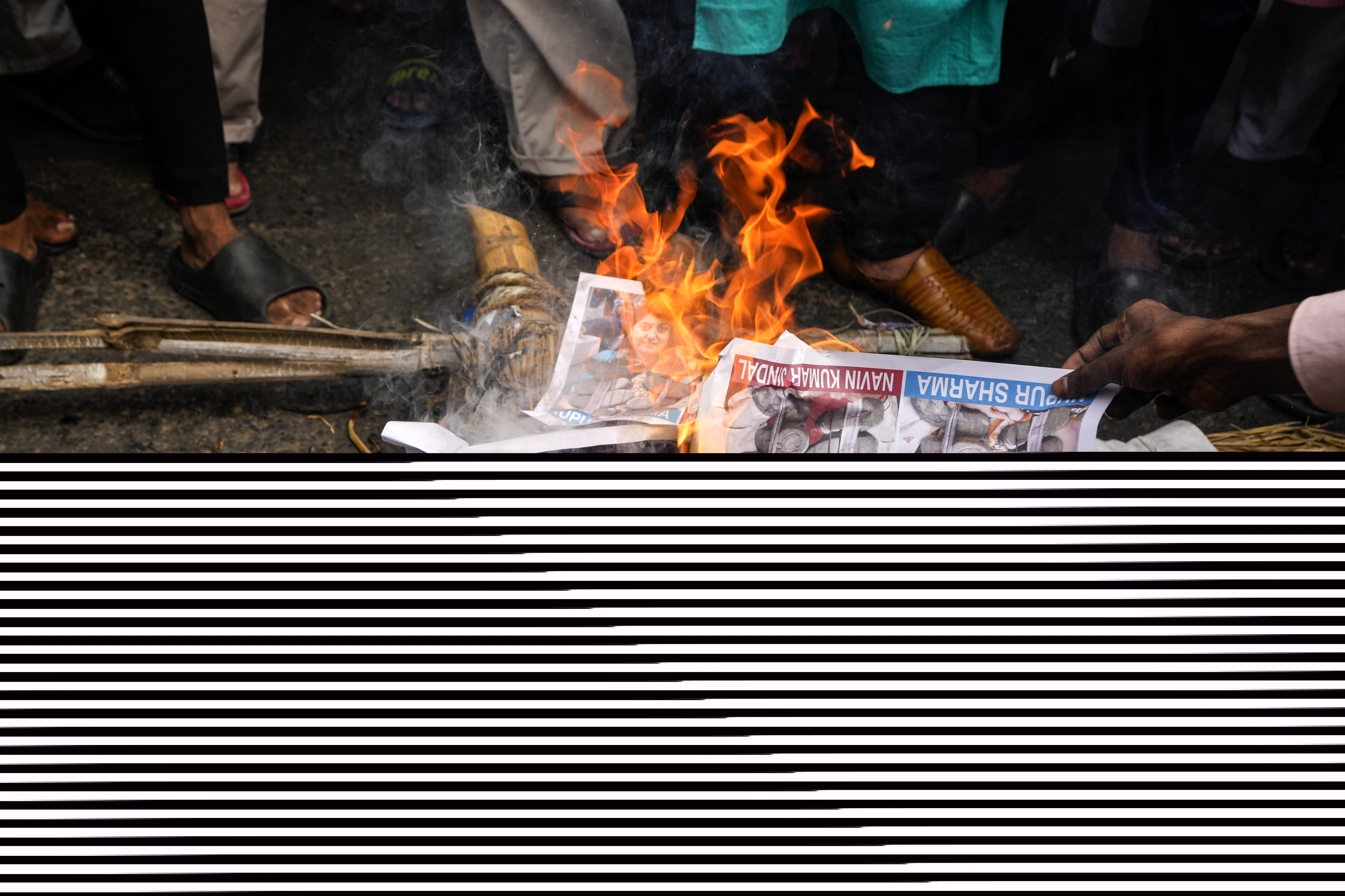 Indian Muslims burn an effigy with portraits of BJP leader Nupur Sharma.