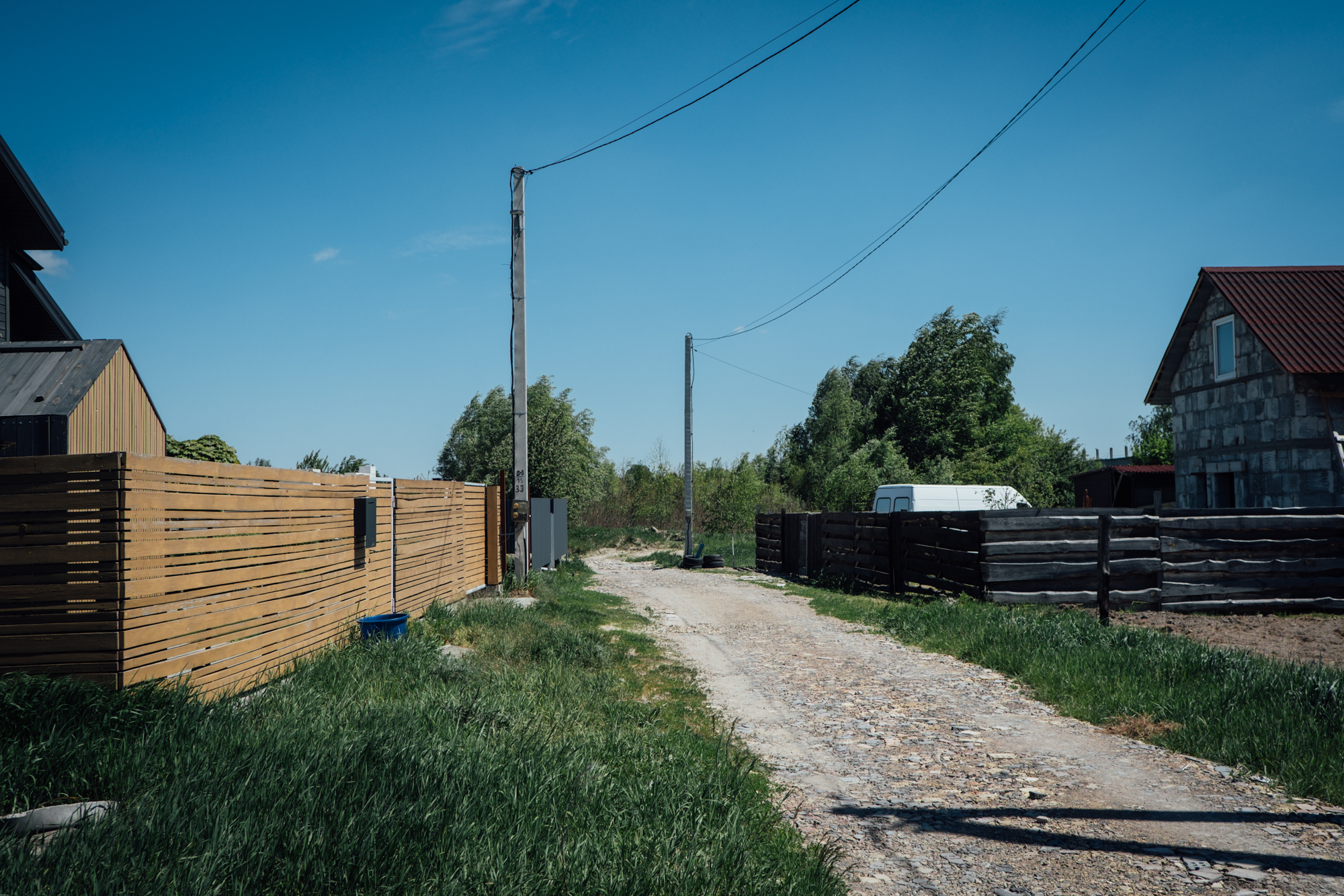 A photo of a view from the road with a misplaced telephone pole.