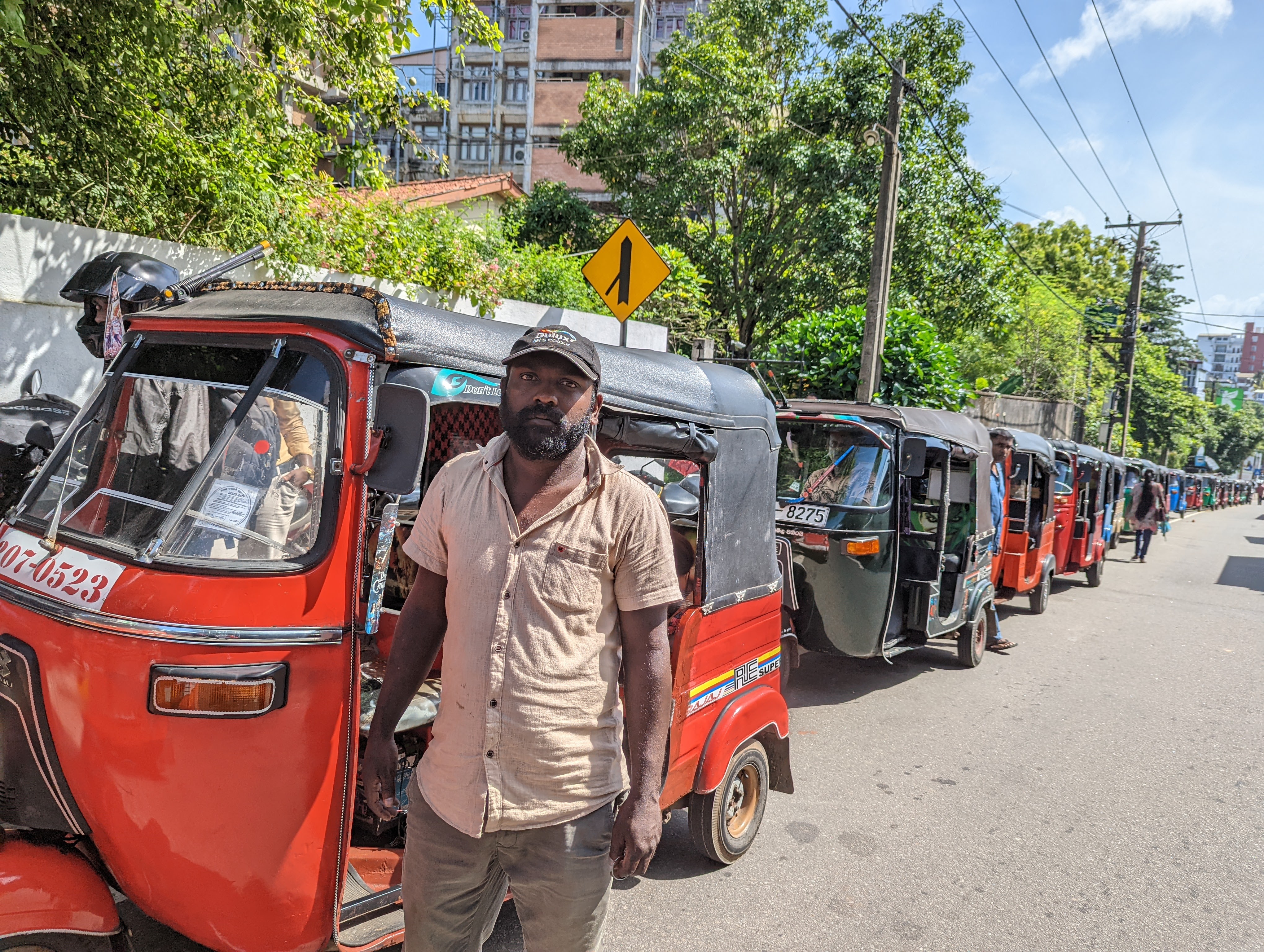 People queue up in rickshaws for fuel