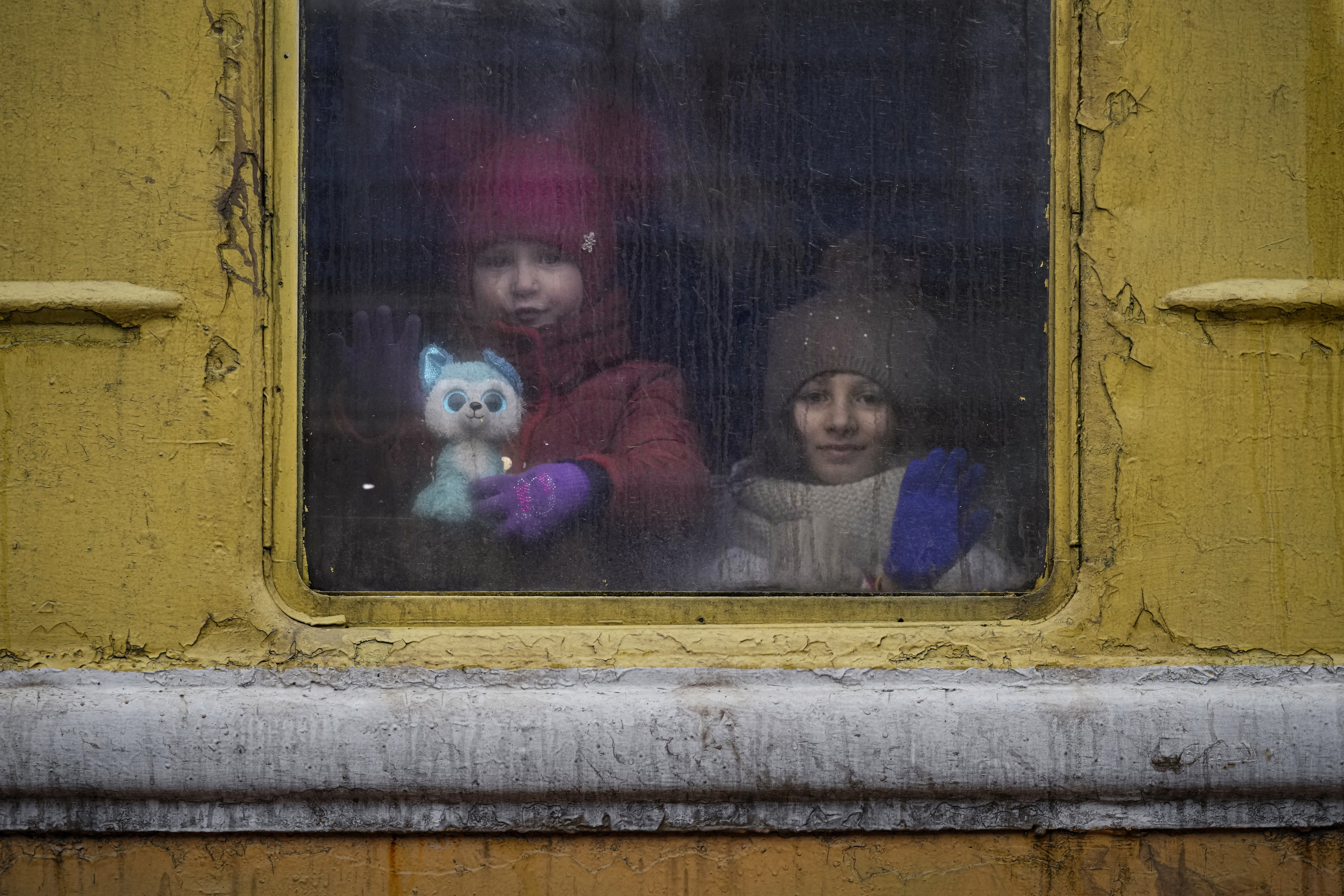 Children look out the window of an unheated Lviv-bound train, in Kyiv, Ukraine.