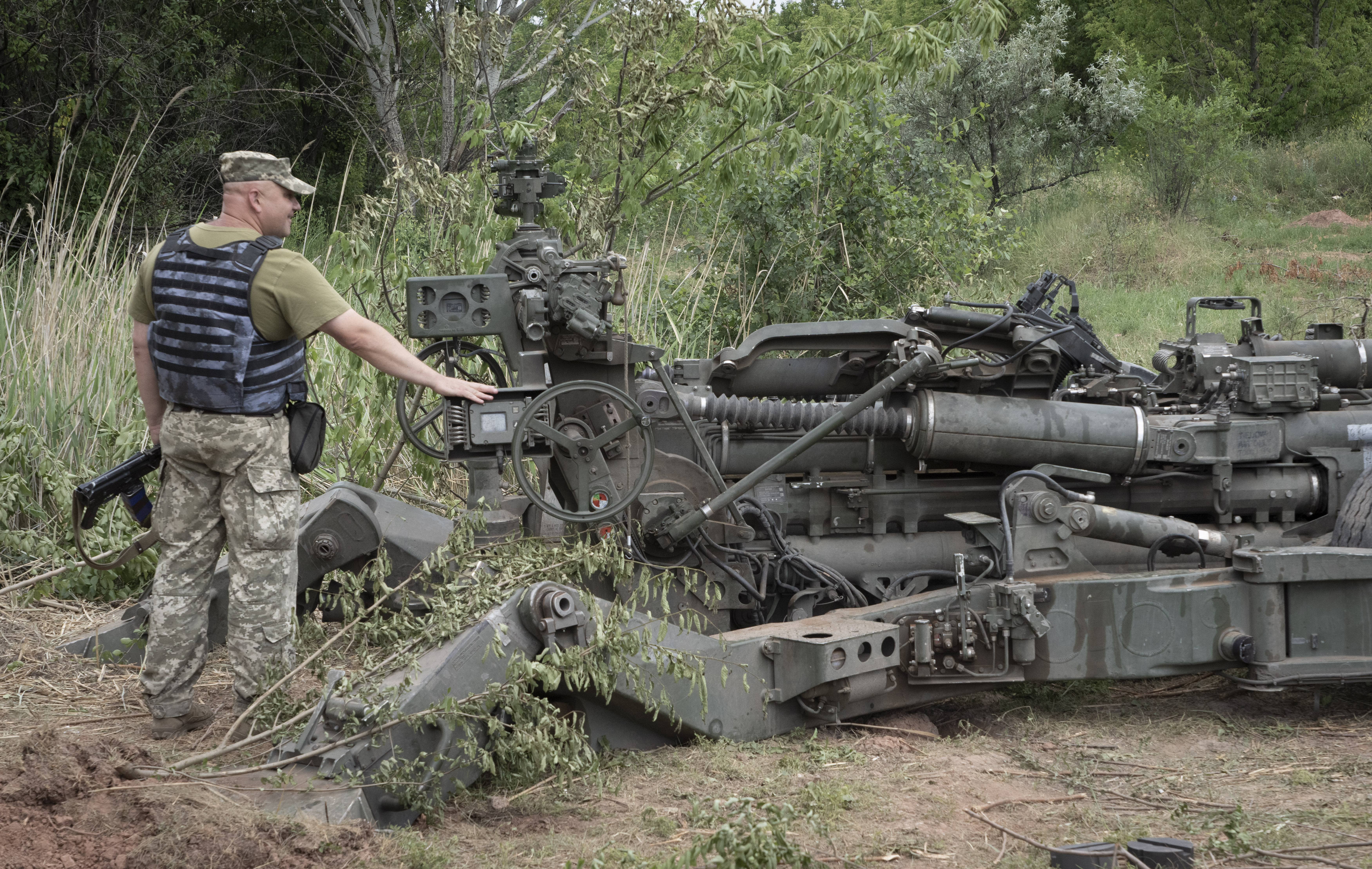 A Ukrainian soldier stands at a US-supplied M777 howitzer in Ukraine's eastern Donetsk region Saturday, June 18, 2022