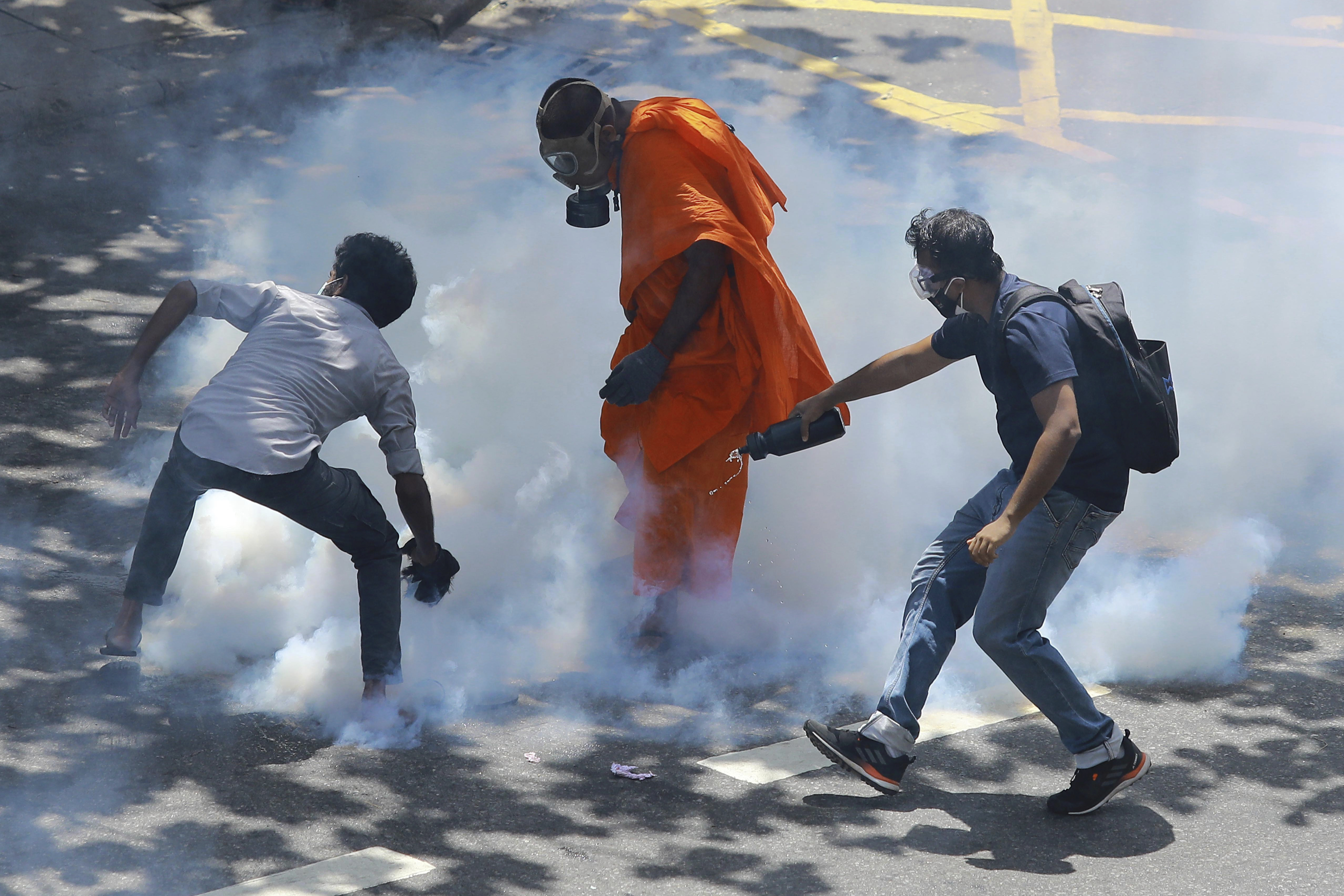 Protesters react after police fired tear gas to disperse them in Colombo