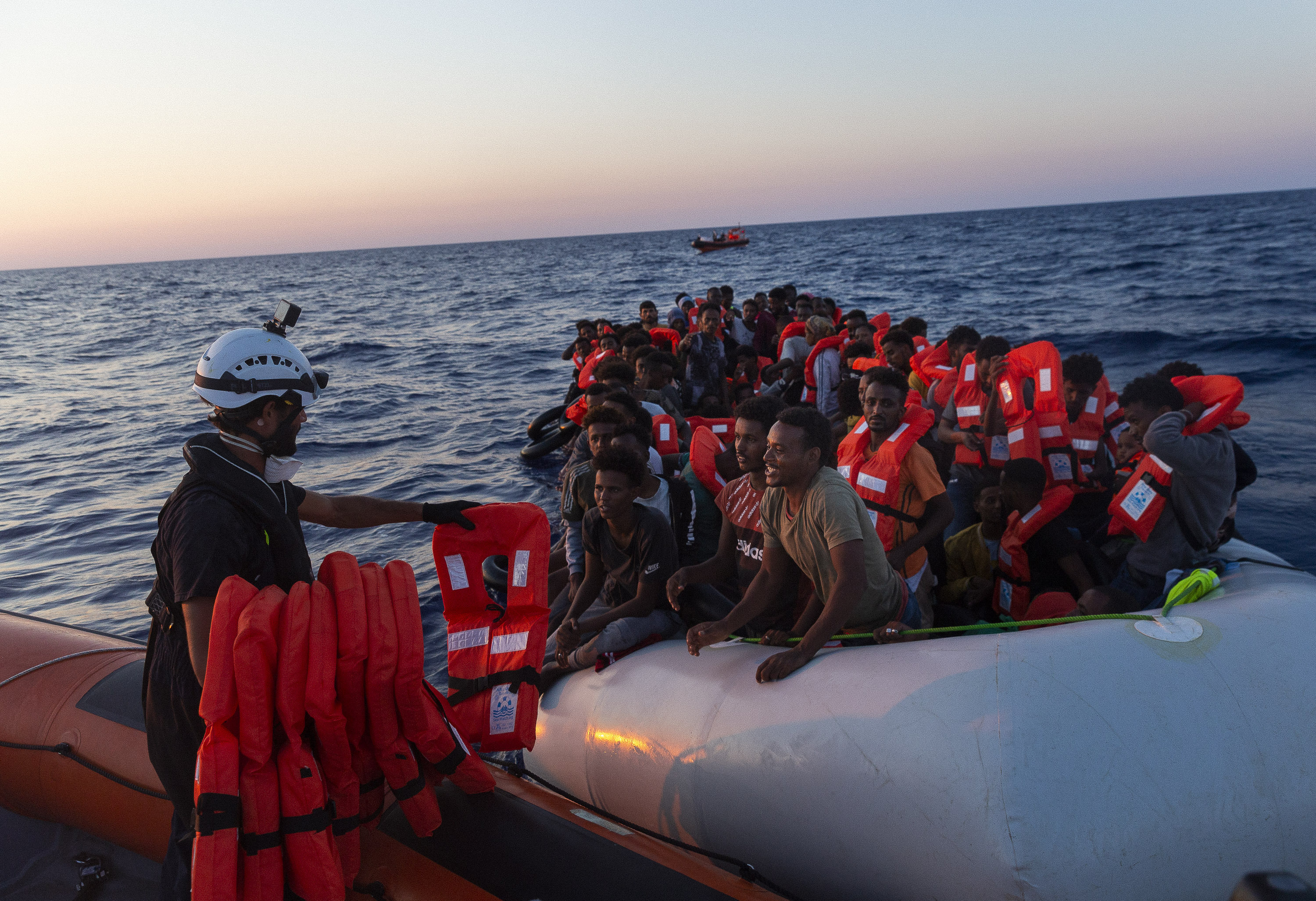 Crew of the Sea-Watch 3 distribute life jackets to 108 people in a boat in distress in the central Mediterranean