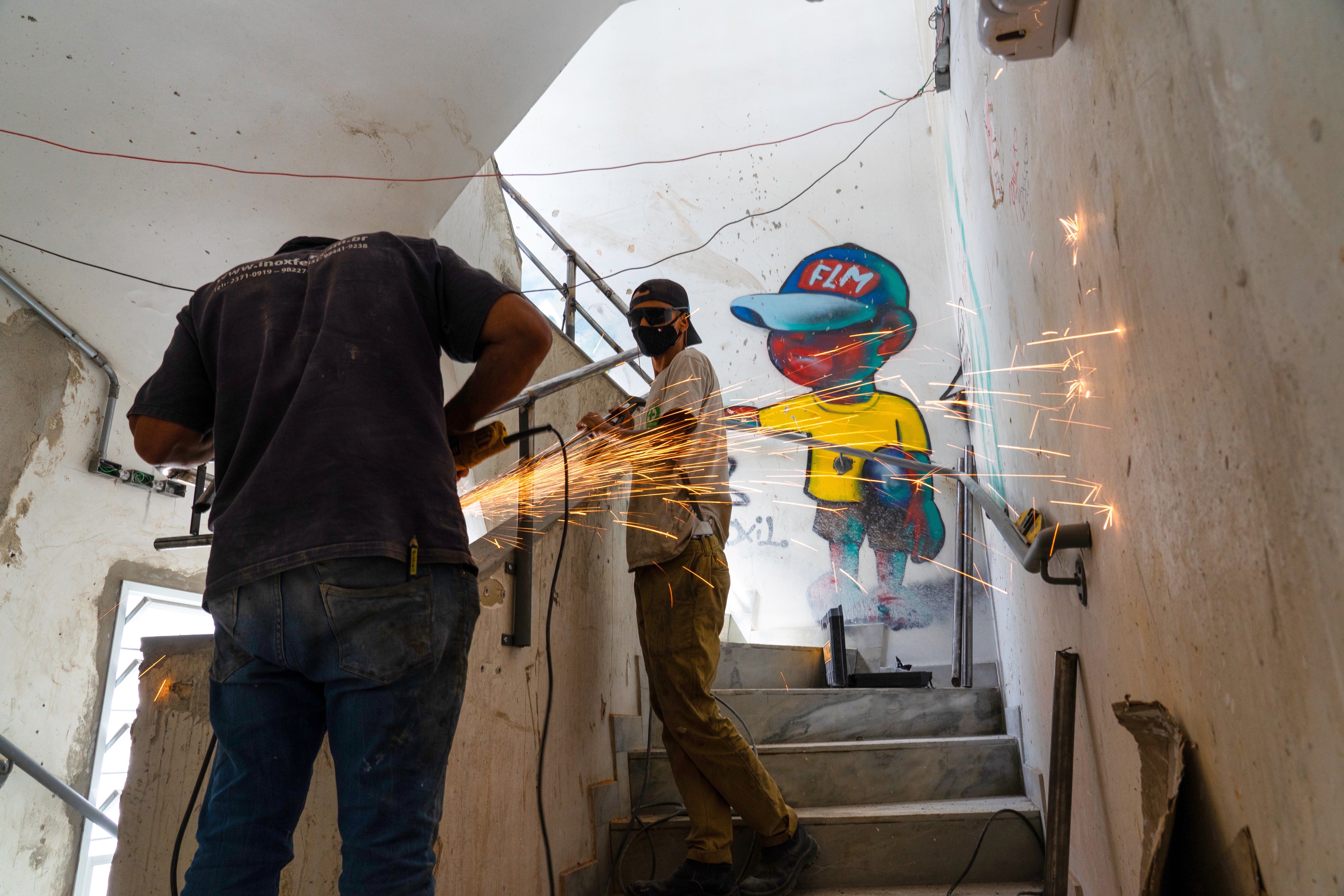 Two men work in fixing the stairwell of Hotel Lord.