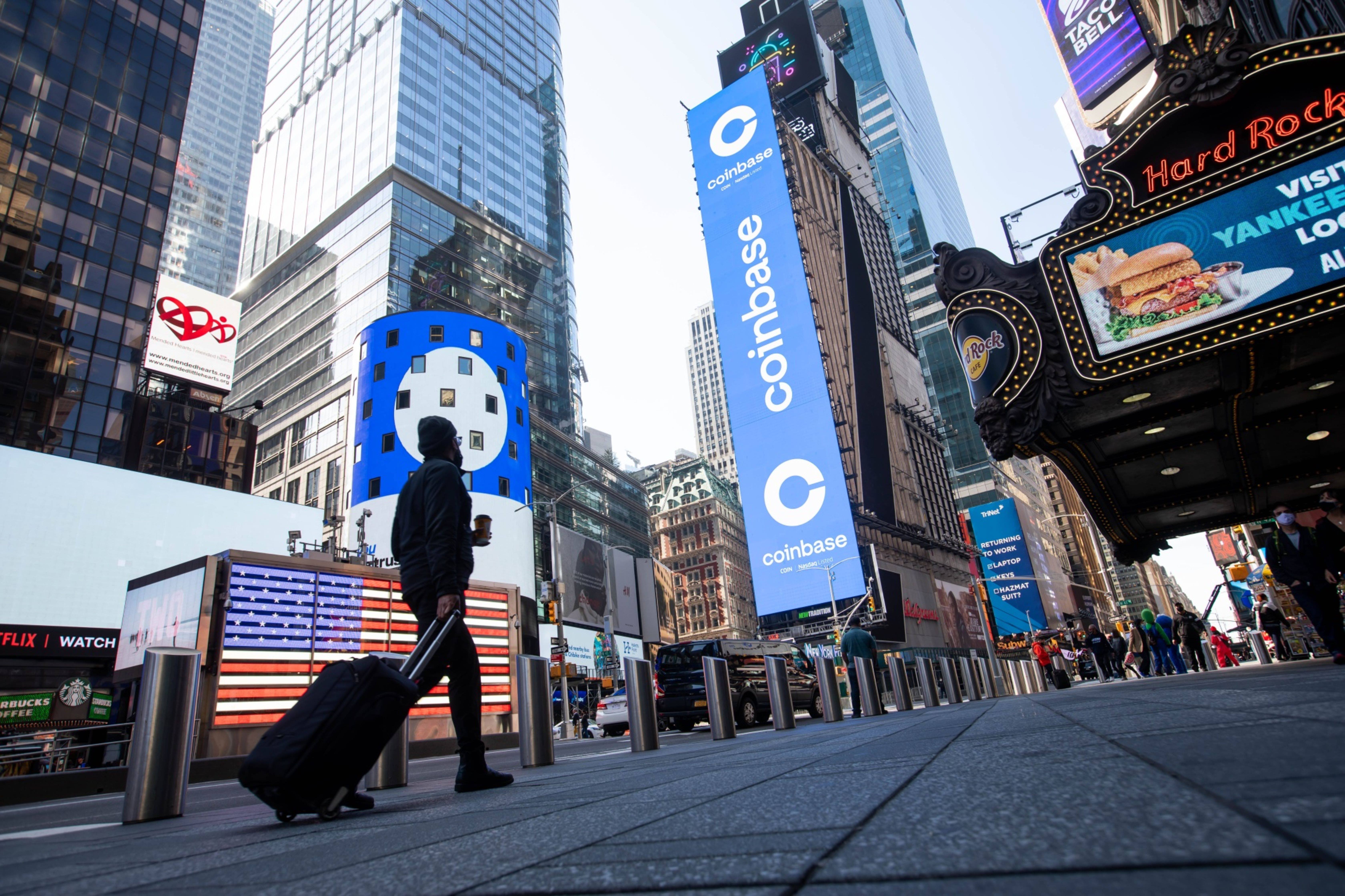 Monitors display Coinbase signage during the company's initial public offering (IPO) at the Nasdaq MarketSite in New York, U.S., on Wednesday, April 14, 2021. Coinbase Global Inc., the largest U.S. cryptocurrency exchange, is set to debut on Wednesday through a direct listing, an alternative to a traditional initial public offering that has only been deployed a handful of times.
