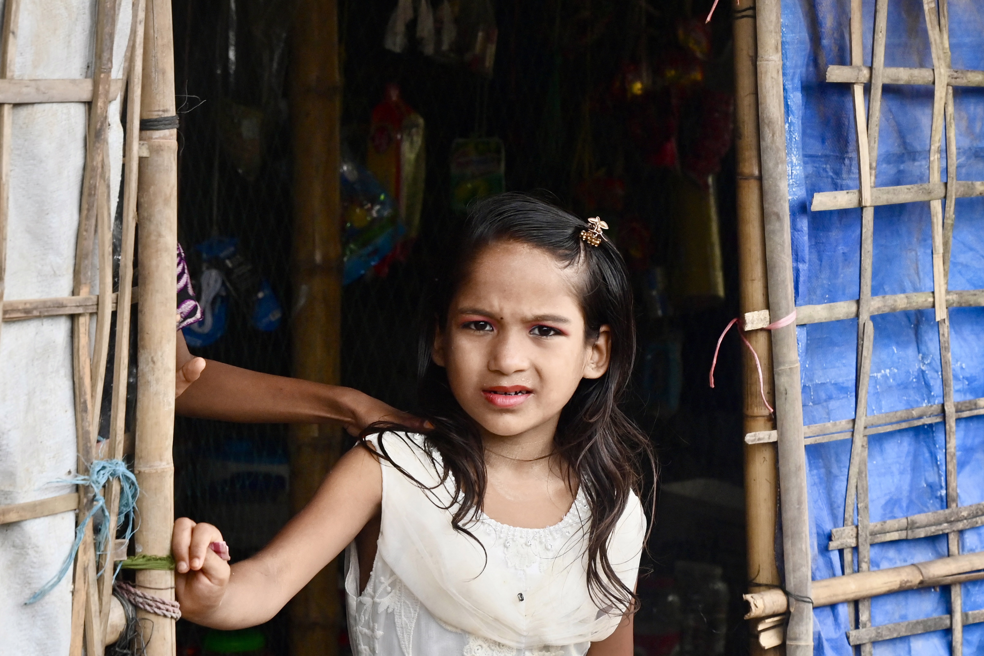 A Rohingya refugee child looks out of a makeshift house in Balulkhali refugee camp in Ukhia