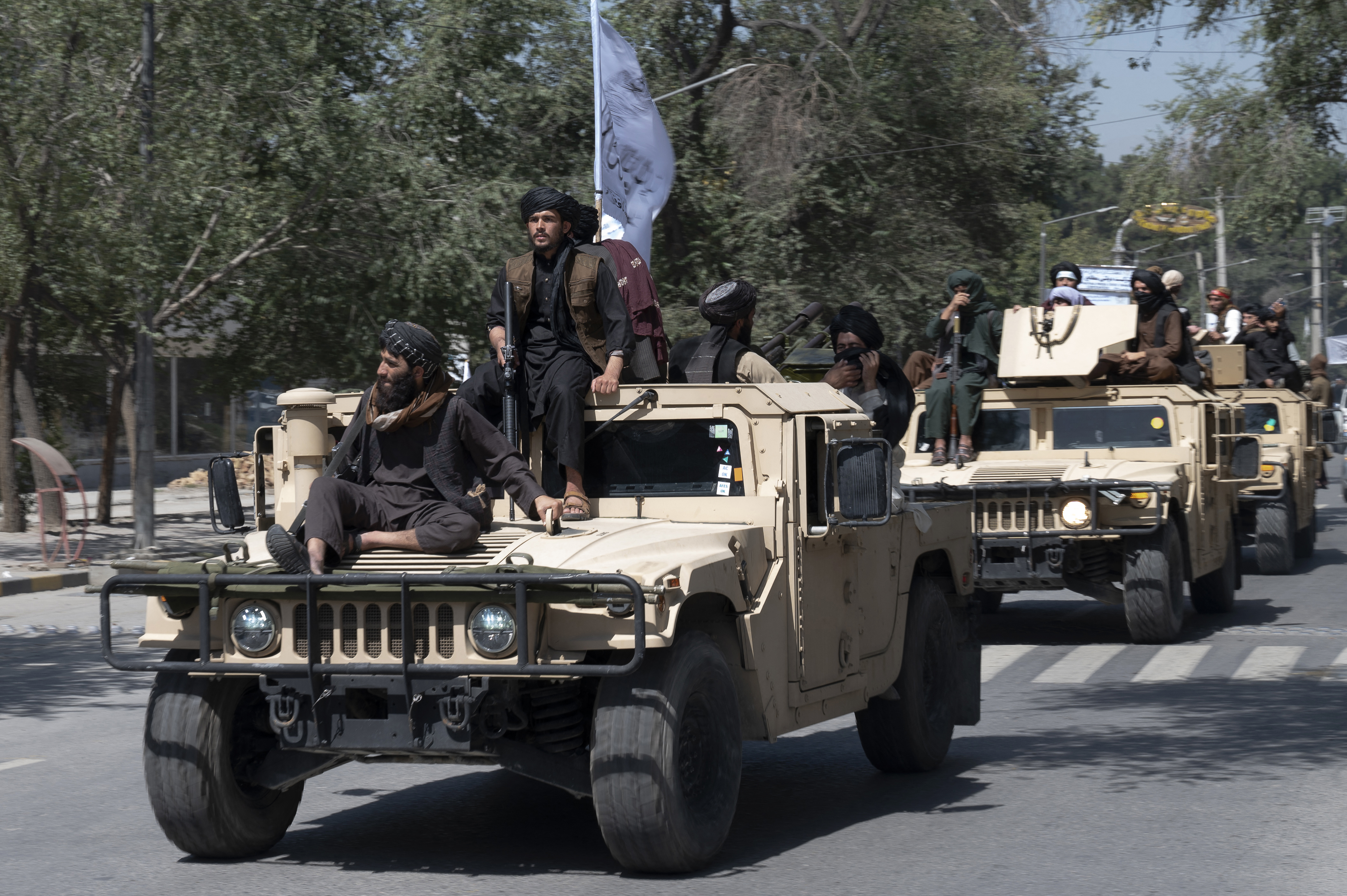Taliban fighters parade on humvee vehicles