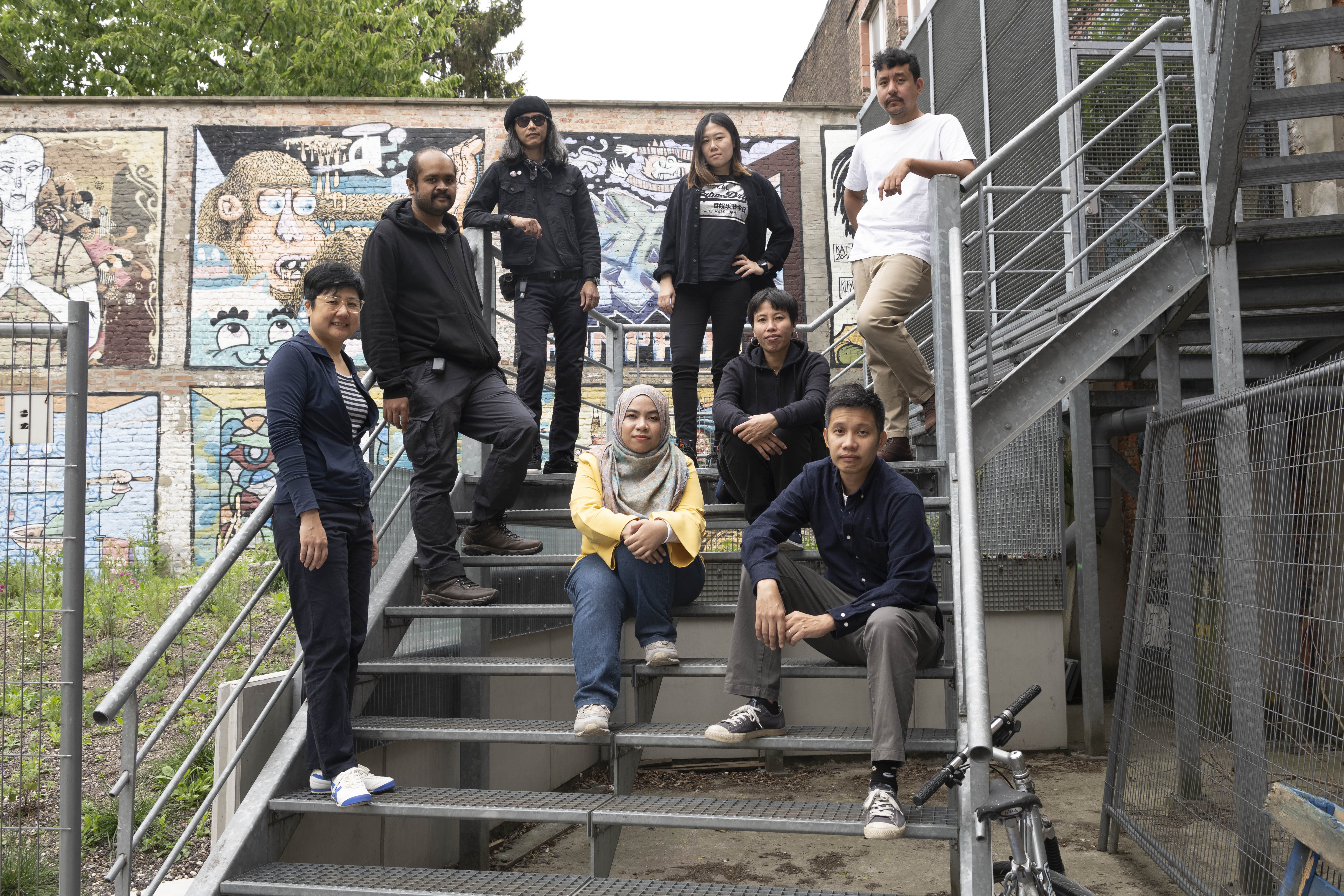 The performers of A Notional History standing on a fire escape at Kunstenfestivaldesarts in Brussels