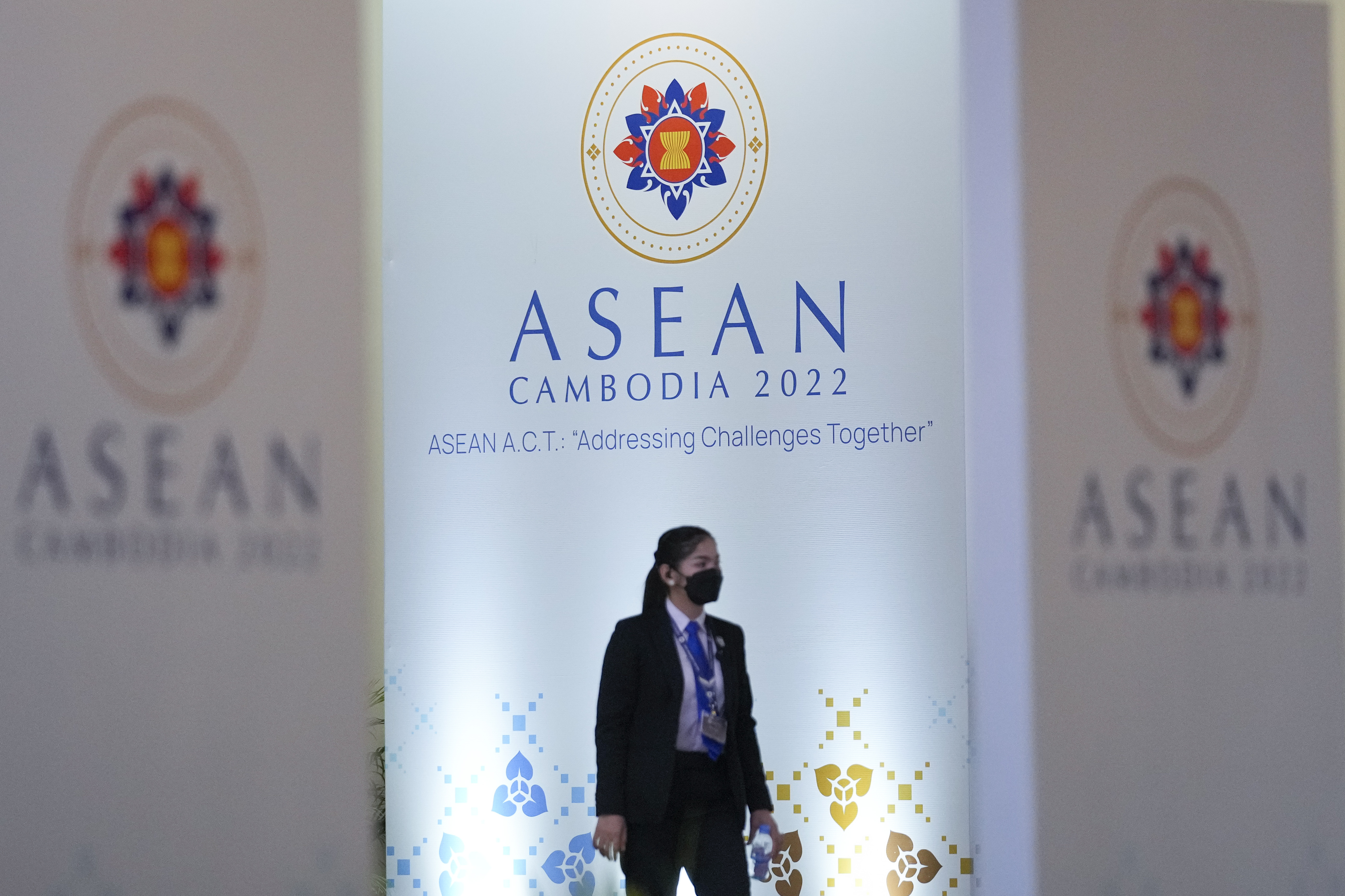 A member of the security team walks in front of the ASEAN hoardings in Phnom Penh