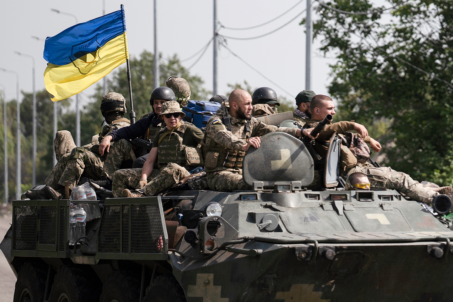 Ukrainian servicemen ride atop of an armored vehicle on a road in Donetsk region, eastern Ukraine, Sunday, Aug. 28, 2022. (AP Photo/Leo Correa)