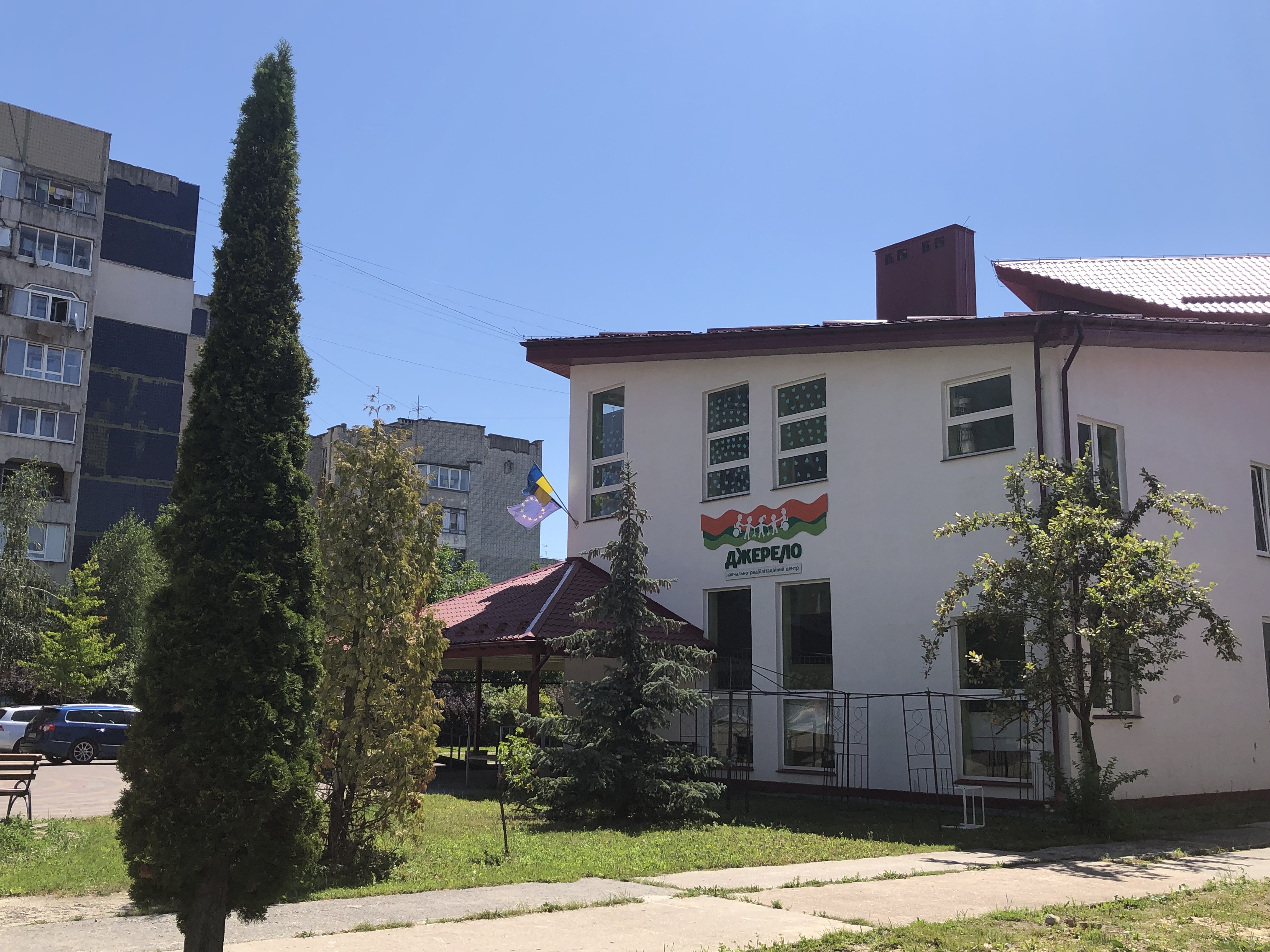 A photo of the Dzherelo Centre building during the day with plants outside.