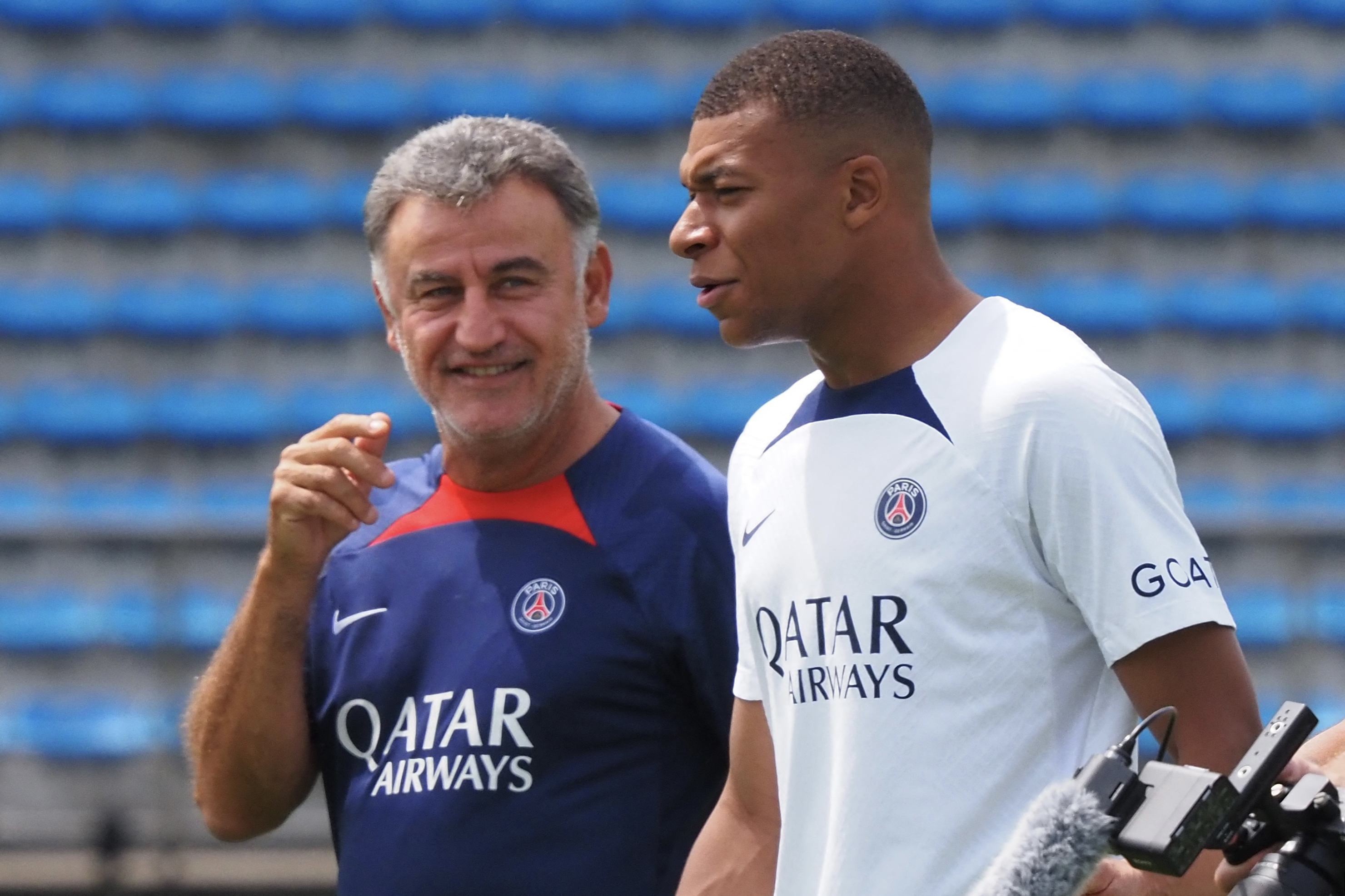 France's football team Paris Saint-Germain player Kylian Mbappe (R) chats with head coach Christophe Galtier while attending a soccer clinic at a stadium in Tokyo on July 18, 2022, as a part of the teams pre-season summer tour of Japan. (Photo by TOSHIFUMI KITAMURA and Toshifumi KITAMURA / AFP)